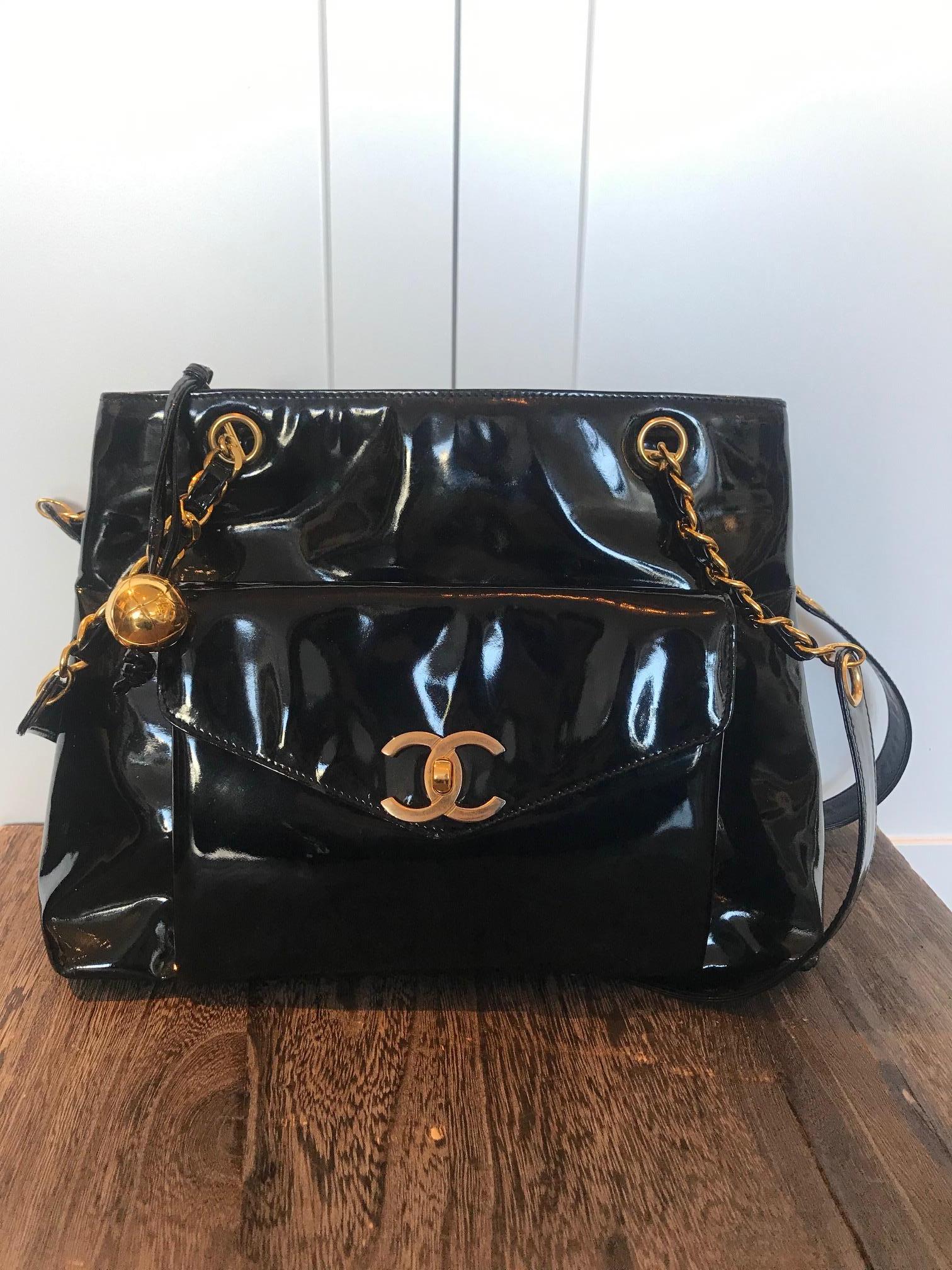 Black patent leather. Gold-tone hardware. Snap closure. Dual flat long shoulder straps featuring classic leather and chain. One open exterior pockets One Exterior pocket with CC turn-lock closure. Leather interior. Three interior compartments with