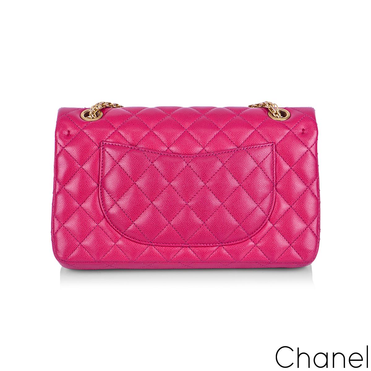 A Chic Chanel 2.55 Reissue Medium Double Flap Handbag. The exterior of this reissue 2.55 is crafted in pink caviar leather with aged gold tone hardware. This reissue bag features both signature diamond and chevron style stitching, which is rare. The