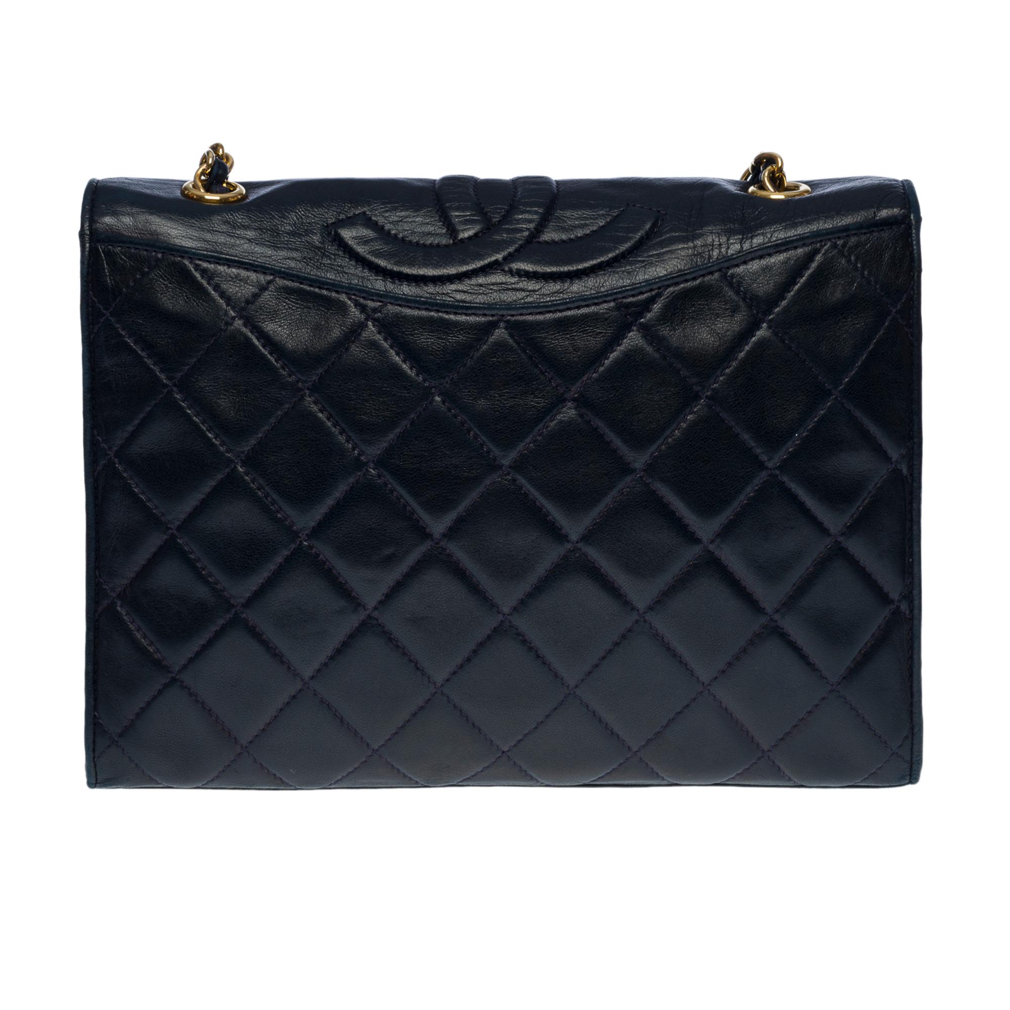 The​ ​Chanel​ ​Full​ ​flap​ ​pockets​ ​shoulder bag​ ​in​ ​navy​ ​quilted​ ​lambskin,​ ​gilt​ ​metal​ ​hardware,​ ​one​ ​chain​ ​strap​ ​in​ ​gilt​ ​metal​ ​interlaced​ ​with​ ​navy​ ​leather​ ​to​ ​be​ ​worn​ ​on​ ​the​ ​shoulder​ ​and​ ​across​