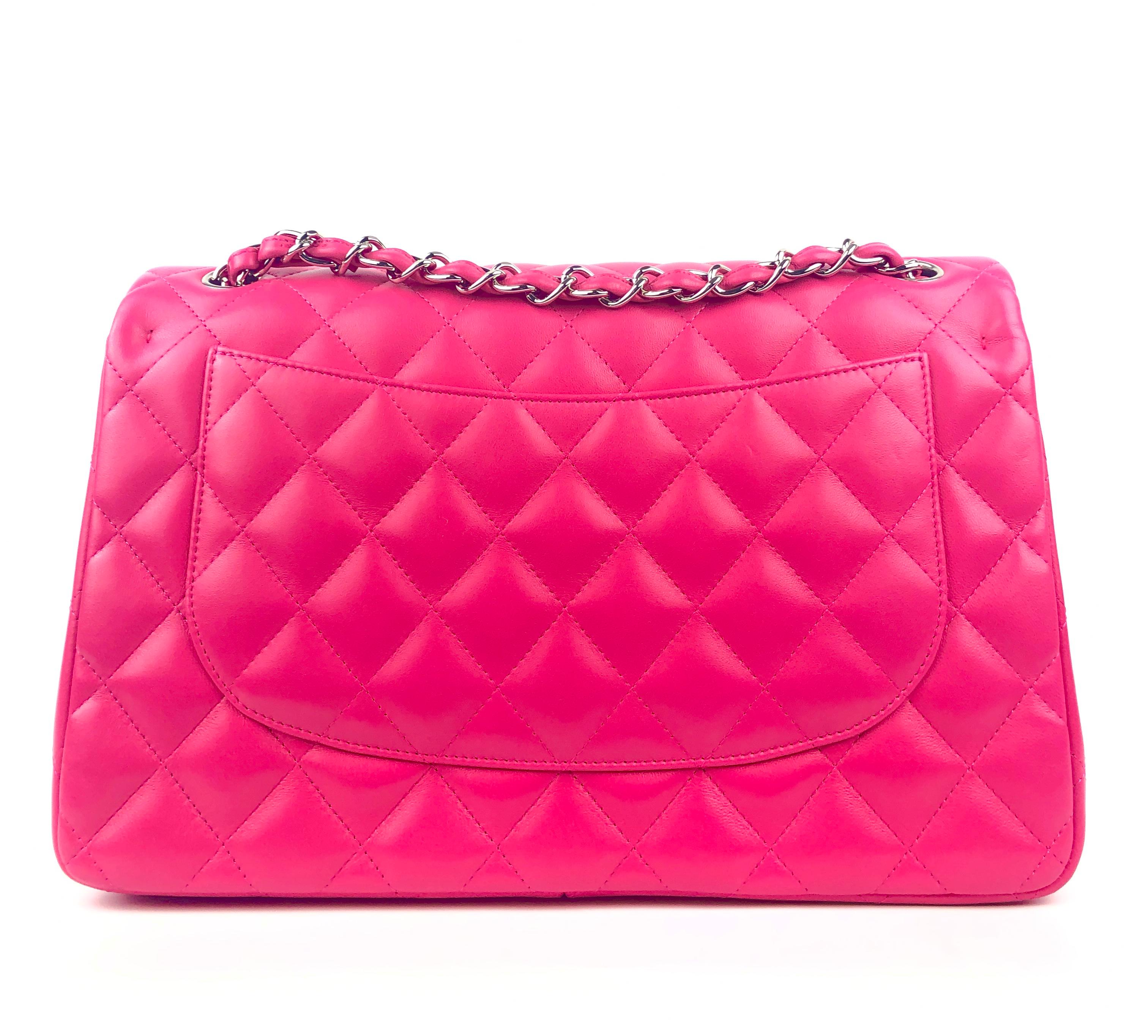 This authentic Chanel Fuschia Lambskin Jumbo Classic Flap is in pristine condition.  The highly sought after Jumbo Classic is breathtaking in this vivid shade of spicy hot pink.
Quilted lambskin with silver tone interlocking CC twist lock on