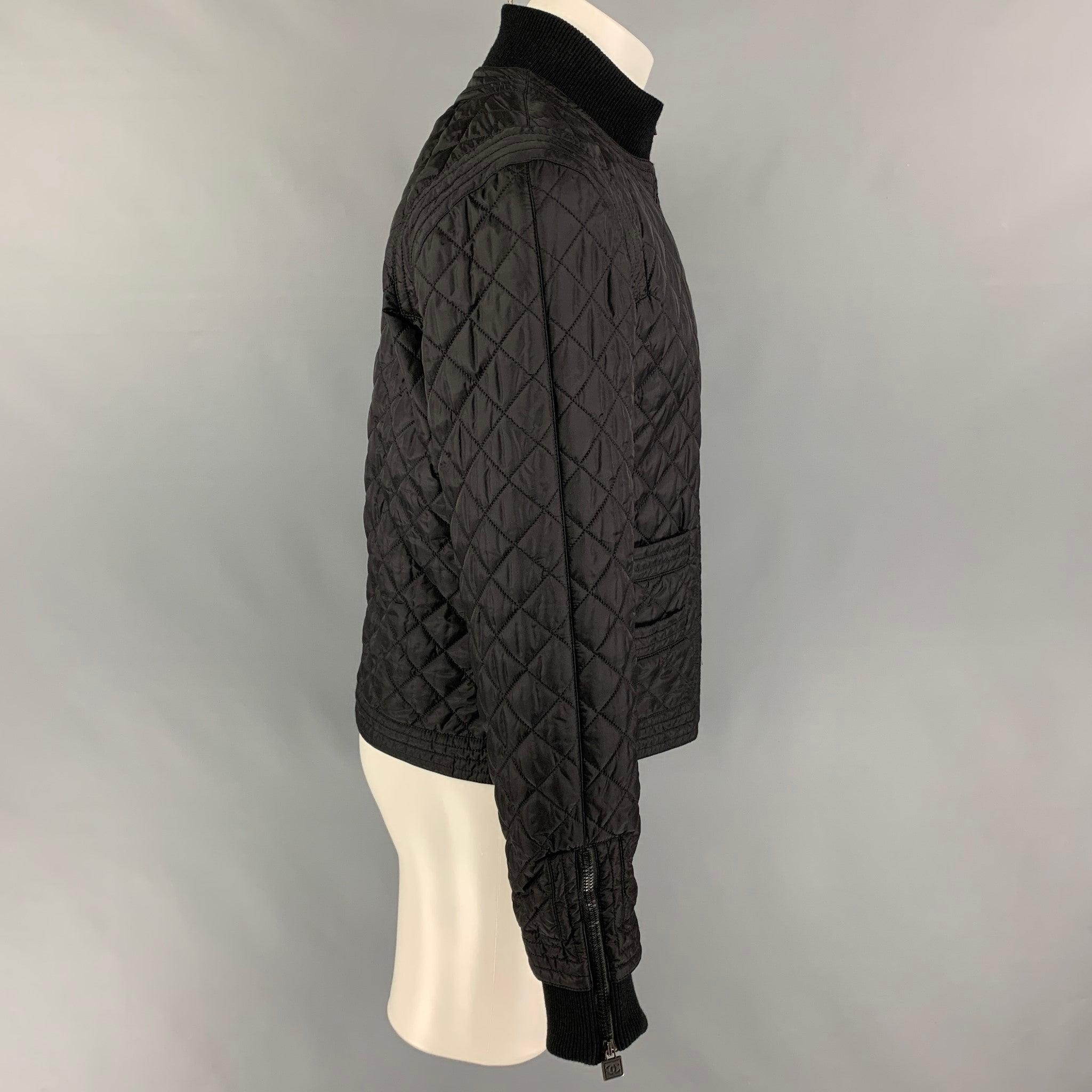 CHANEL Fall-Winter 2005 jacket comes in a black quilted polyamide blend featuring a high collar, ribbed hem, slit pockets, zipped sleeves, logo hardware, and a full zip up closure. Made in Italy.
 Excellent
 Pre-Owned Condition. 
 

 Marked:  05A /