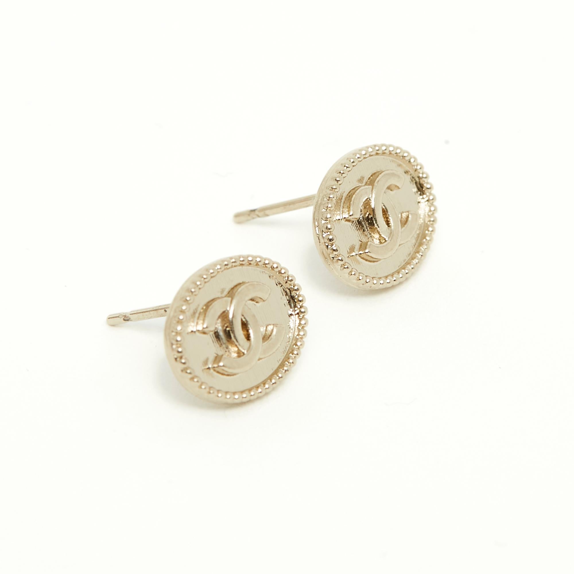 Chanel stud earrings in oval gold metal topped with a small CC and edged with an ultra-fine pearl motif. Width 1.25 cm x height 0.9 cm. The earrings are delivered without invoice or original packaging but they are in very good condition, from a