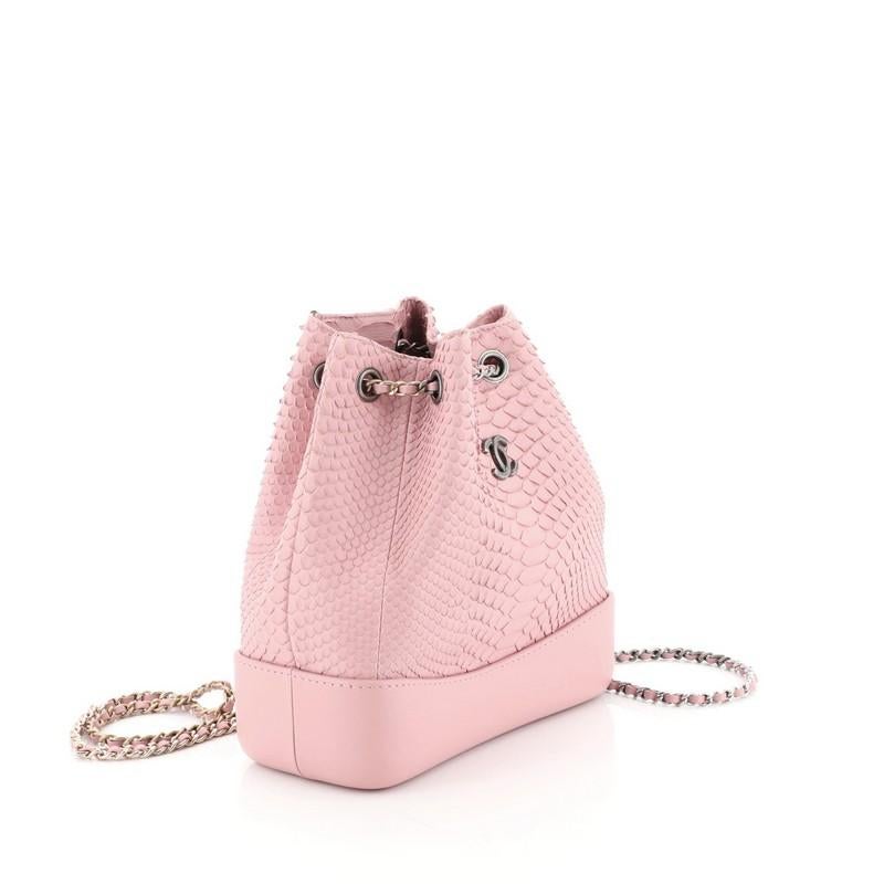 This Chanel Gabrielle Backpack Python Small, crafted from genuine pink python, features gradient woven-in leather chain straps threaded through eyelets, CC logo at front, and gold and gunmetal-tone hardware. It opens to a pink leather interior with