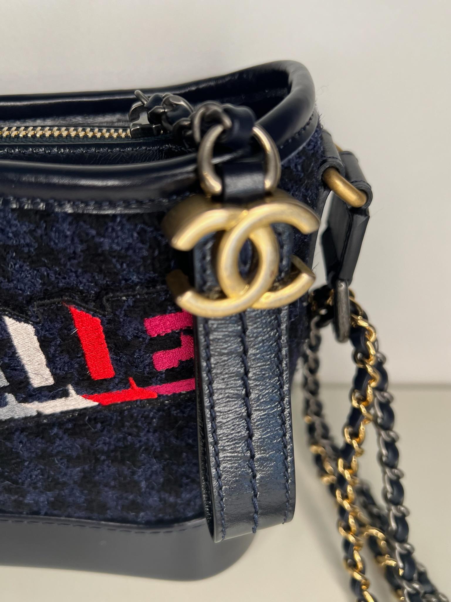 Ce sac hobo Gabrielle super chic de la Collection SALL 2017 de Chanel présente un extérieur en tweed et cuir marine avec un motif 'Gabrielle' multicolore sur le tweed. Le sac est également doté d'une quincaillerie antique multicolore et d'une