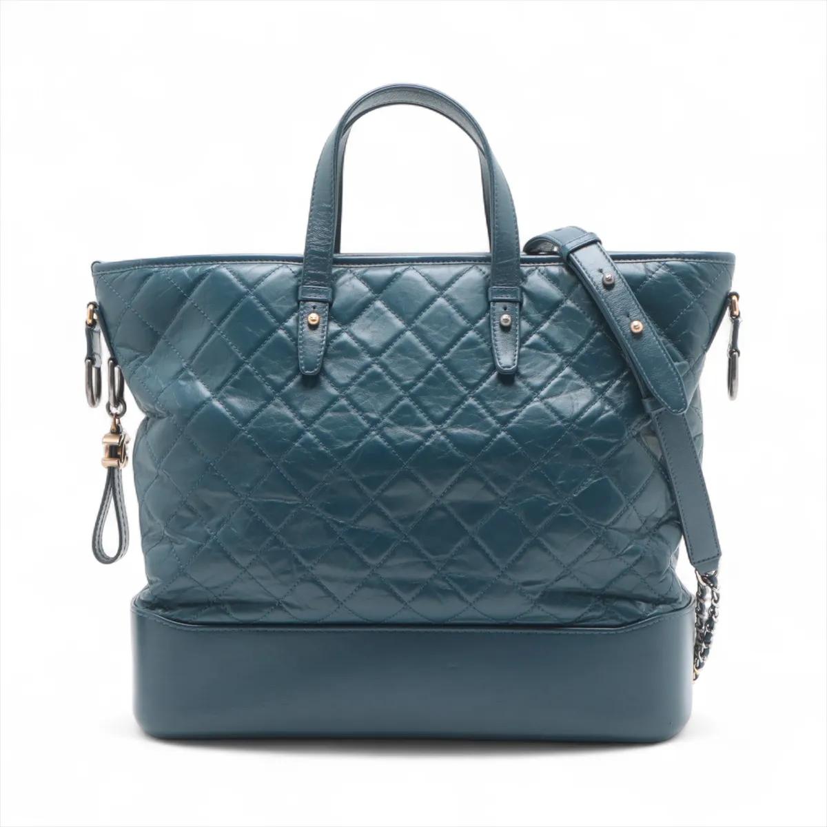 Le sac fourre-tout à deux voies Chanel Gabrielle Doo Vintage en veau matelassé bleu marine est une pièce sophistiquée qui allie l'élégance à la praticité. Confectionné en cuir de veau souple avec le matelassage signature de Chanel, il dégage un