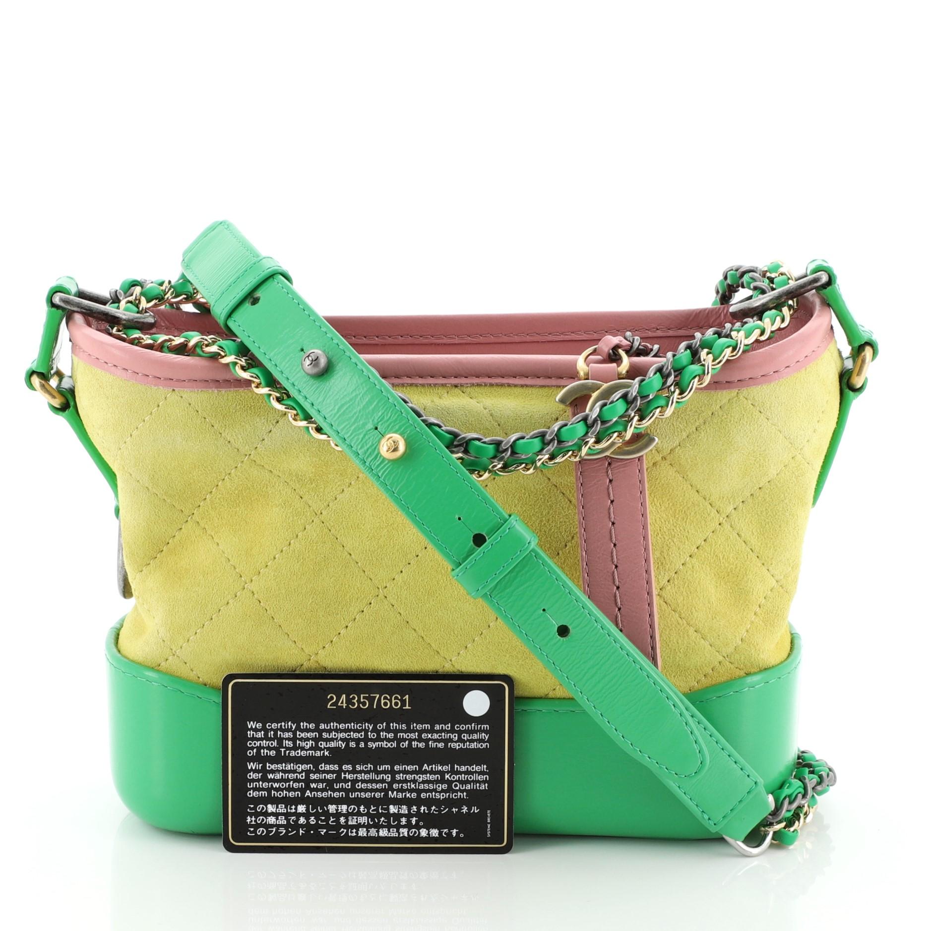 This Chanel Gabrielle Hobo Quilted Suede Small is classic piece with a distinctive shape that was inspired by the structured silhouette of a binocular case. Crafted from yellow quilted suede and green and pink leather, it features woven-in leather