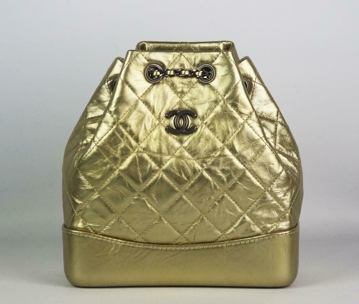 Made in Italy, this beautiful Chanel backpack has been made from gold aged calfskin exterior with red canvas interior, this piece is decorated with Chanel's antiqued-silver logo on the front and finished with a gold and antiqued silver duel chain