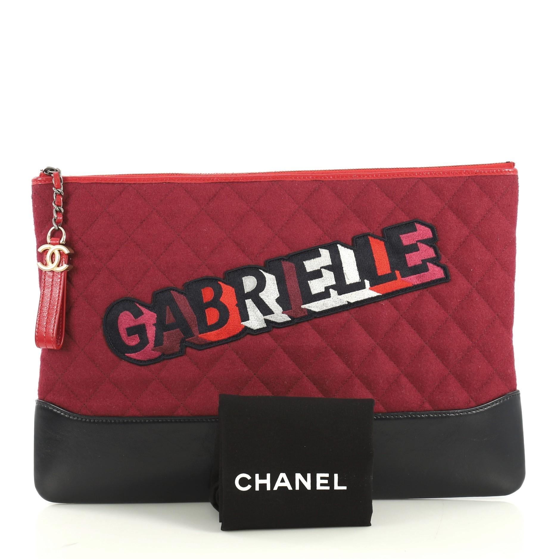 This Chanel Gabrielle O Case Clutch Quilted Felt and Calfskin Large, crafted in purple quilted felt and calfskin leather, features silver-tone hardware. Its zip closure opens to a purple fabric interior. Hologram sticker reads: 24547031. 

Estimated