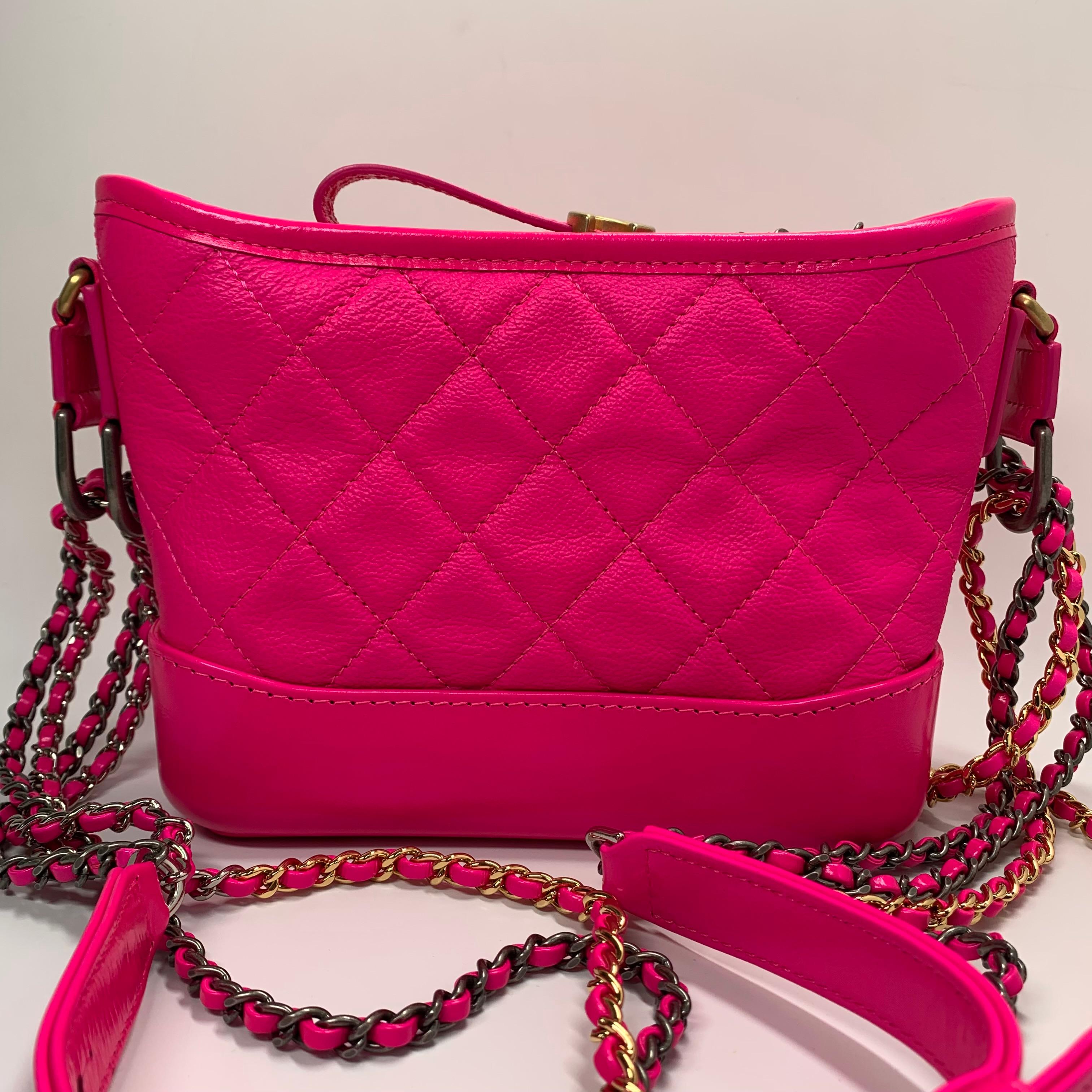 The Chanel Gabrielle bag, a tribute to the iconic Gabrielle 'Coco' Chanel, is presented here in a vibrant neon pink lambskin, a striking reinterpretation of Karl Lagerfeld's design. This piece seamlessly blends classic Chanel elegance with a bold,