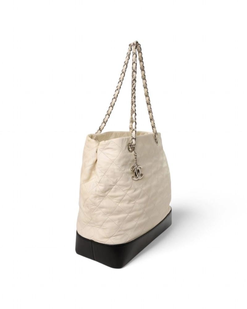 Chanel signature bag, model Gabrielle Tote in size Large, made of white leather with black leather inserts and silver hardware. Featuring a zippered top closure, internally lined in beige fabric with convenient pockets, the bag is quite roomy.