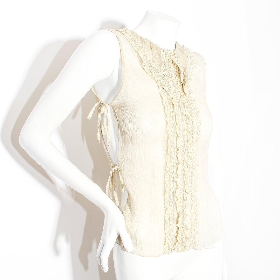 Gauze tank by Chanel 
Spring 2008 collection 
Cream color 
Lace ruffle front 
Open sides with tie closure 
Pointed collar 
Slip-on
Keyhole button back closure 
Sheer
Sleeveless
Made in Italy 
100% silk 
Condition: Excellent, little to no visible