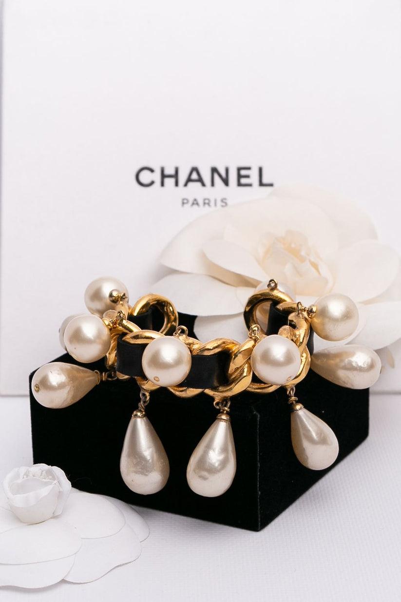 Chanel- (Made in France) Armband aus vergoldetem Hartmetall, umwickelt mit schwarzem Leder, am Ende mit Perlentropfen verziert. 2cc5 Collection'S.

Zusätzliche Informationen:


Abmessungen: 
Umfang des Handgelenks: 13,5 cm (5.31