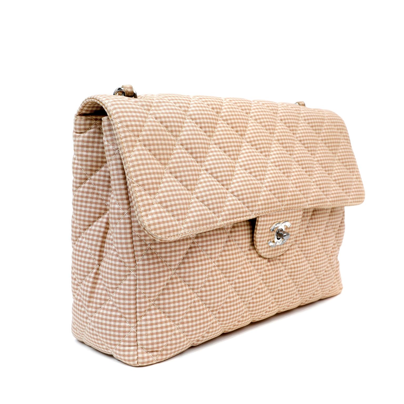 This authentic Chanel Gingham Fabric Maxi Flap Bag is in good previously owned condition.  Very unique and collectible style.  Tan ad cream gingham check fabric is quilted in signature Chanel diamond pattern.  Silver tone interlocking CC twist lock