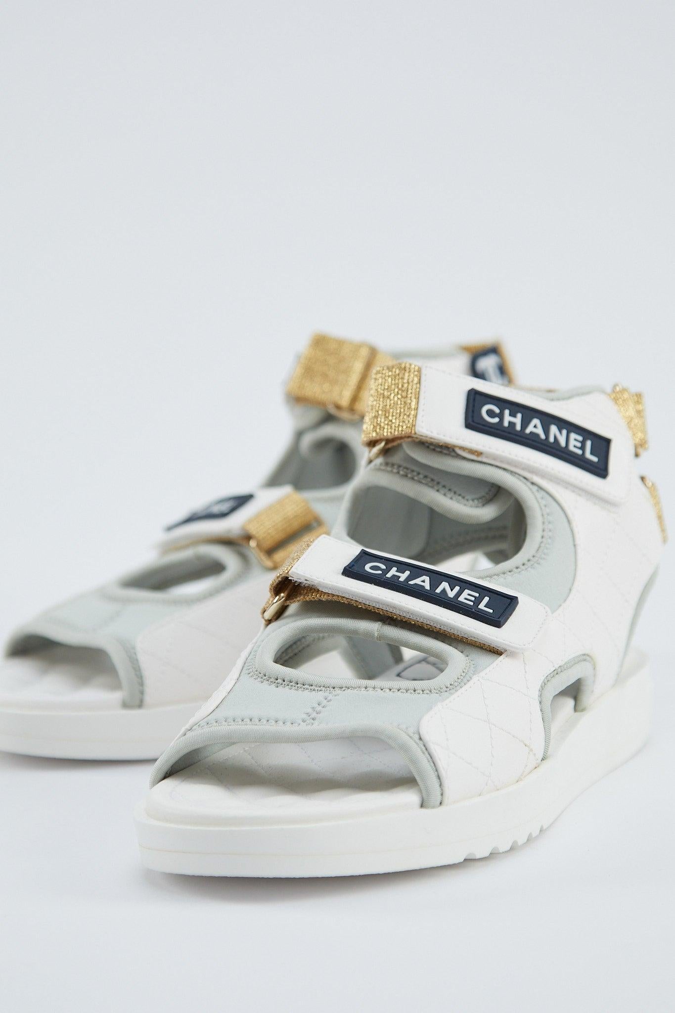 Chanel Gladiator Sandal 

Grey Jersey fabric with white leather trim

Ankle straps, velcro uppers and navy blue Chanel logo

Quilted insole & gold stretch heel detail

Comes with box, no dustbags

Size 38.5