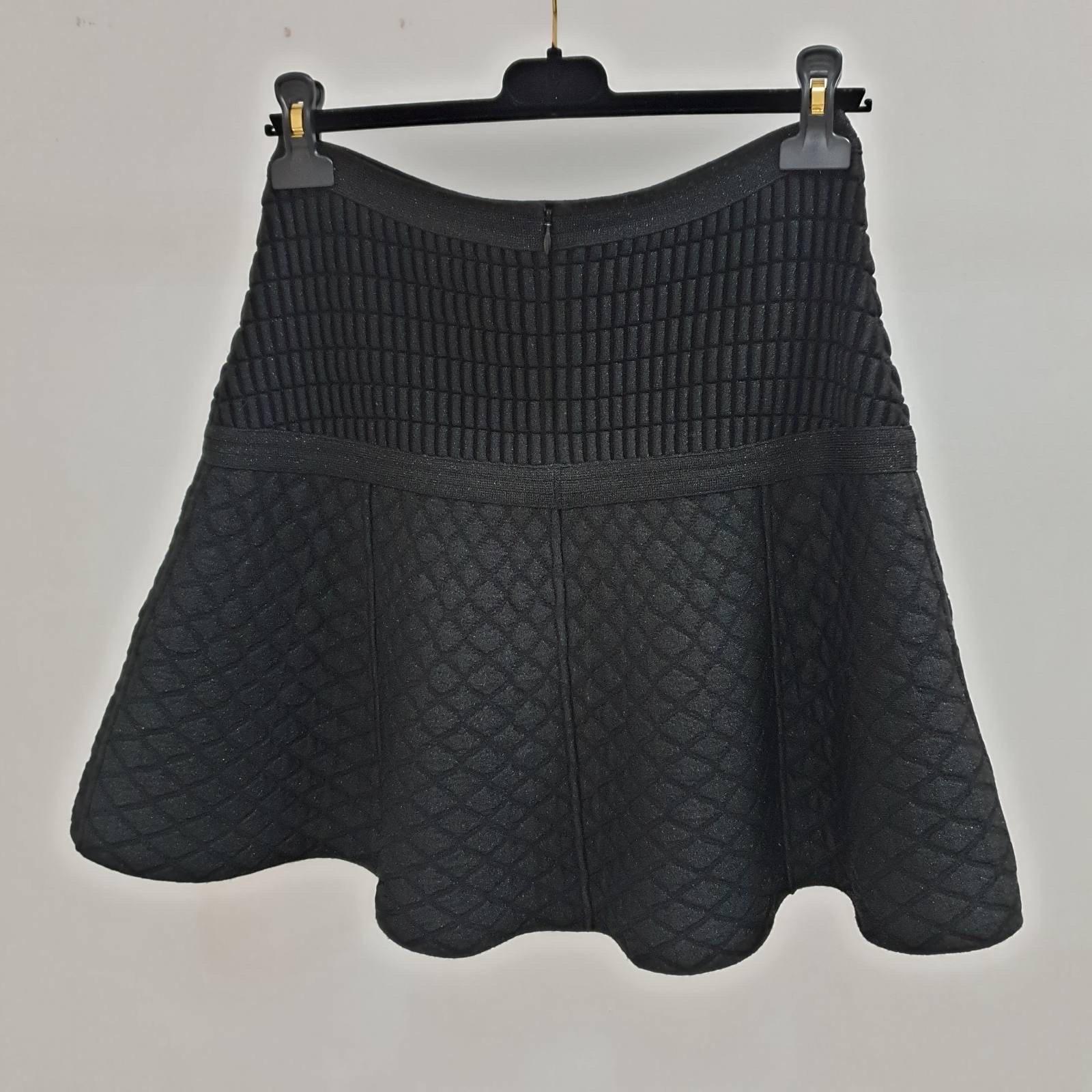 
From Globalization collection.
Chanel short black skirt skater featuring a center back zip, front pockets with decorative buttons, a fancy mix wool and polypropylene textured fabric.

 Sz.36
Very good condition
