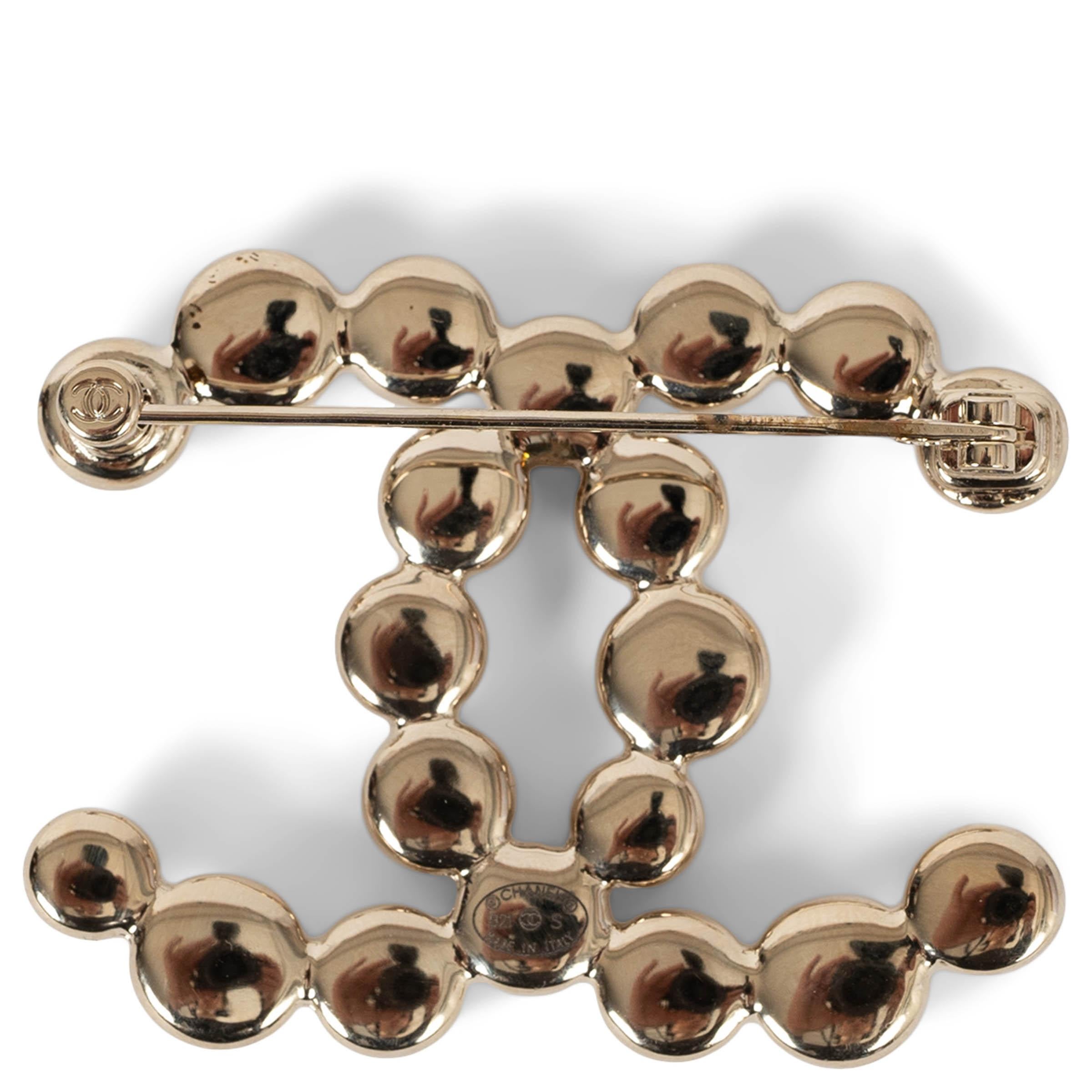Cette broche 100% authentique Chanel Large CC en métal doré beige est une interprétation raffinée de l'emblème de la maison. Confectionné avec des perles complexes, il est d'une élégance et d'une texture discrètes. Une pièce intemporelle qui ajoute