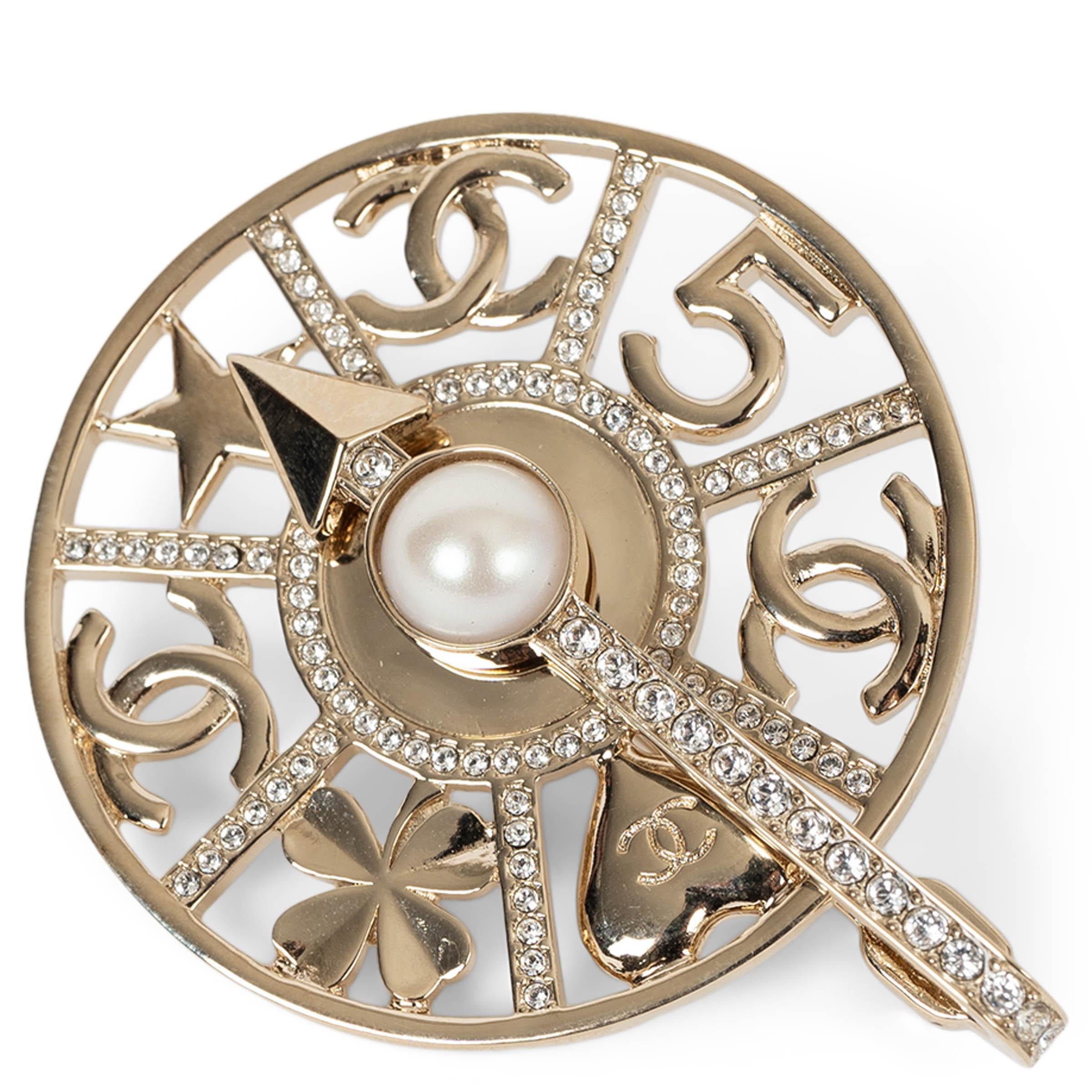 This 100% authentic Chanel Spinning Wheel brooch in gold-tone metal is a playful yet sophisticated statement piece. Adorned with shimmering strass, the wheel features iconic Chanel symbols, including the CC, star, heart, and four-leaf clover,