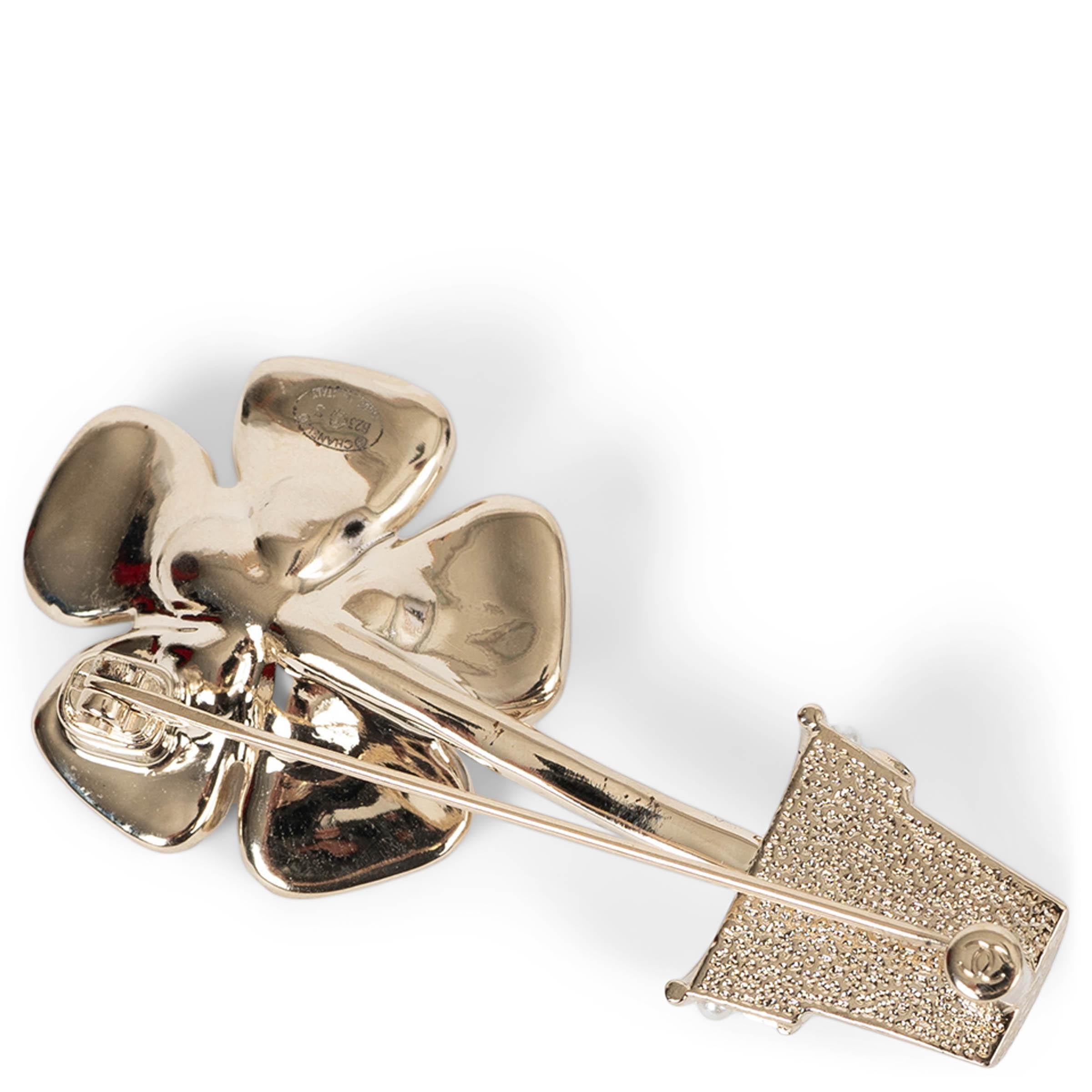 This 100% authentic Chanel potted flower brooch in gold-tone metal is a whimsical yet elegant accessory. Delicately detailed with pearly white resin pearls and sparkling strass, it captures the maison’s signature blend of luxury and charm. A