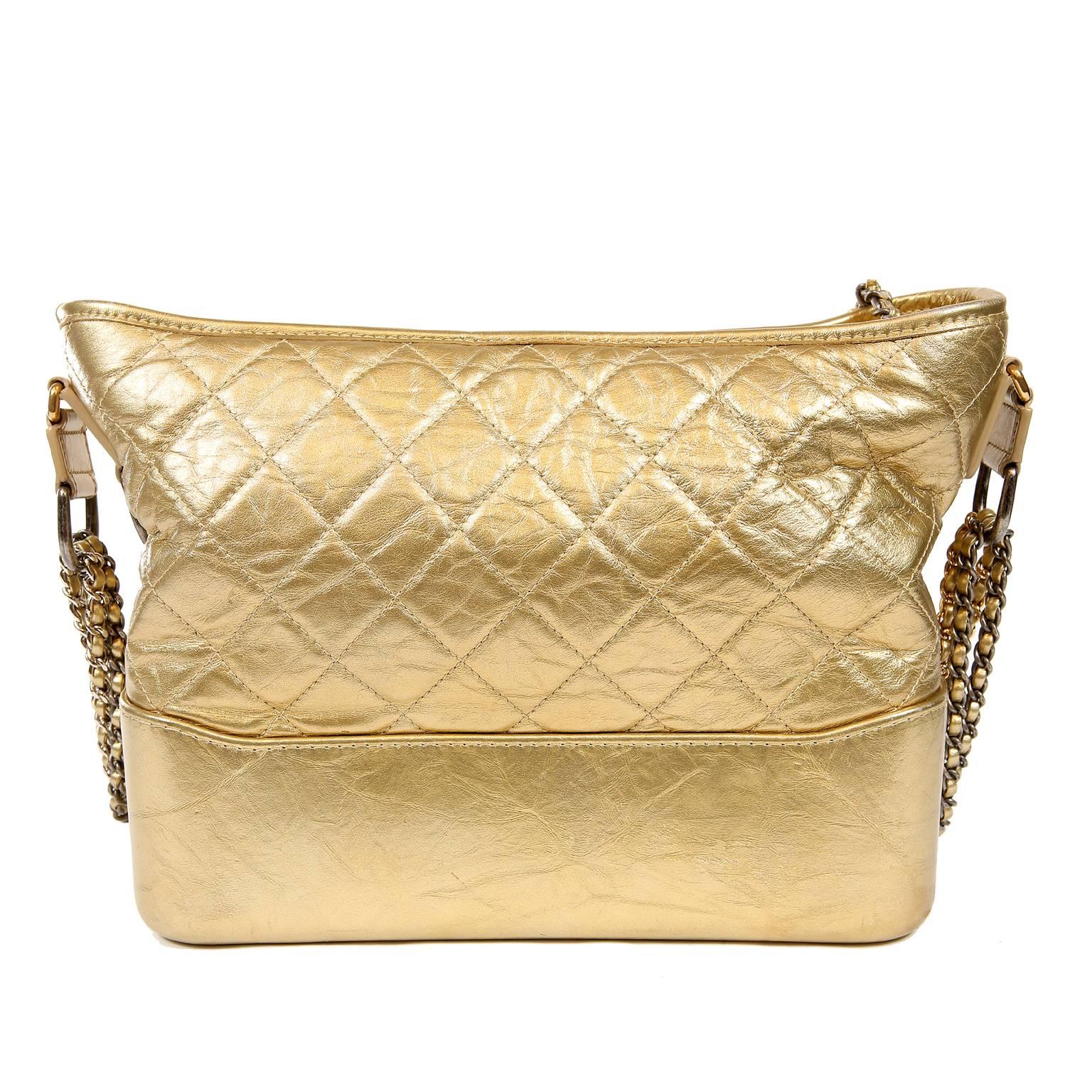 Chanel Gold Aged Calfskin Gabrielle Crossbody Hobo- PRISTINE; appears never carried.
Chanel’s newest silhouette, the Gabrielle, in matte metallic gold.  Intentionally “distressed” gold aged calfskin with signature Chanel diamond quilting on top