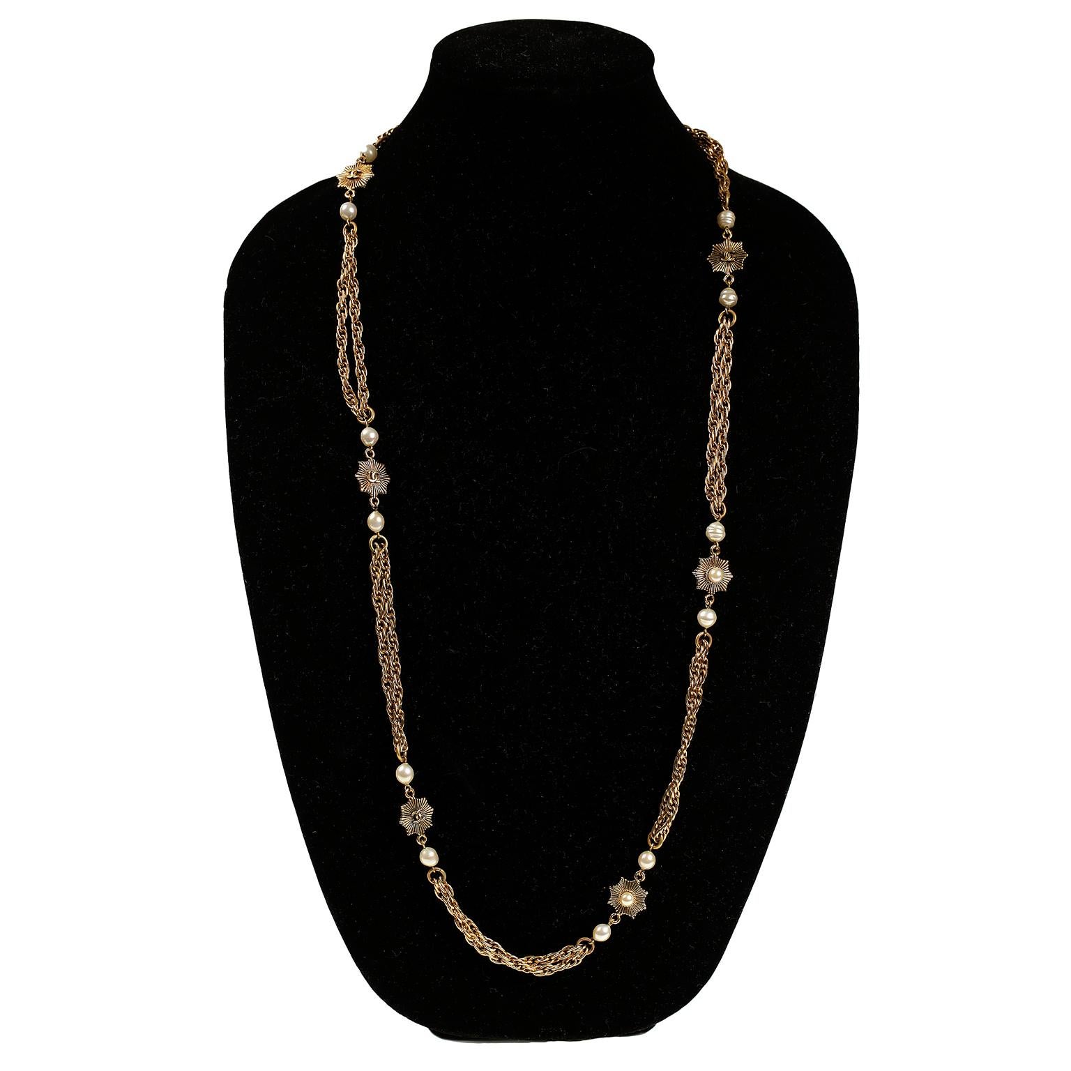 This authentic Chanel Gold and Pearl Double Strand Necklace is in very good condition from the 1984 collection.  Gold linked doubled chains are separated by small starburst flower stations, each with an interlocking CC centered on the back and
