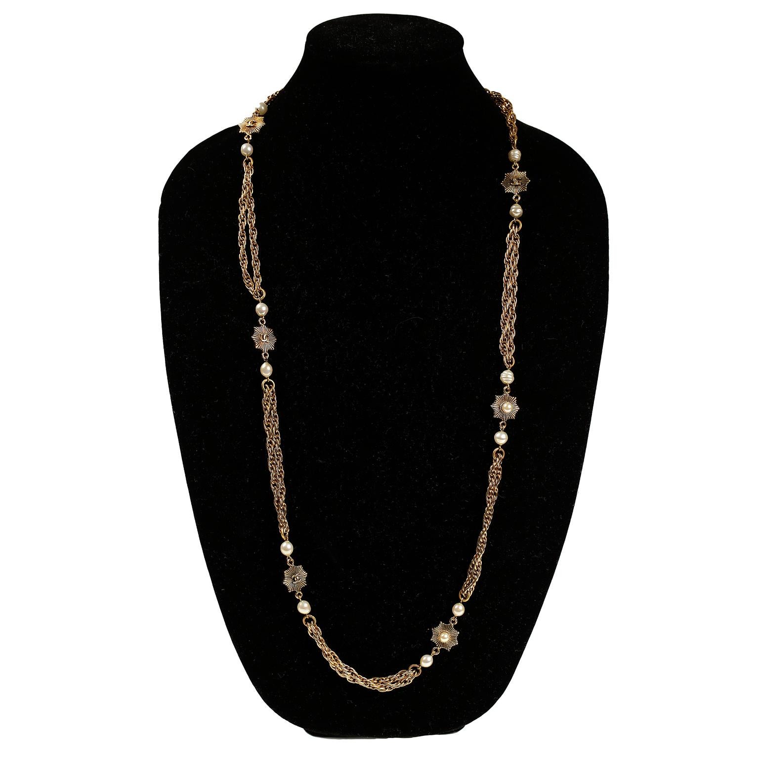 Diese authentische Chanel Gold- und Perlen-Doppelstrang-Halskette ist in sehr gutem Zustand aus der Collection'S von 1984.  Die goldfarbenen Doppelketten sind durch kleine Starburst-Blumenstationen getrennt, die jeweils ein ineinandergreifendes CC