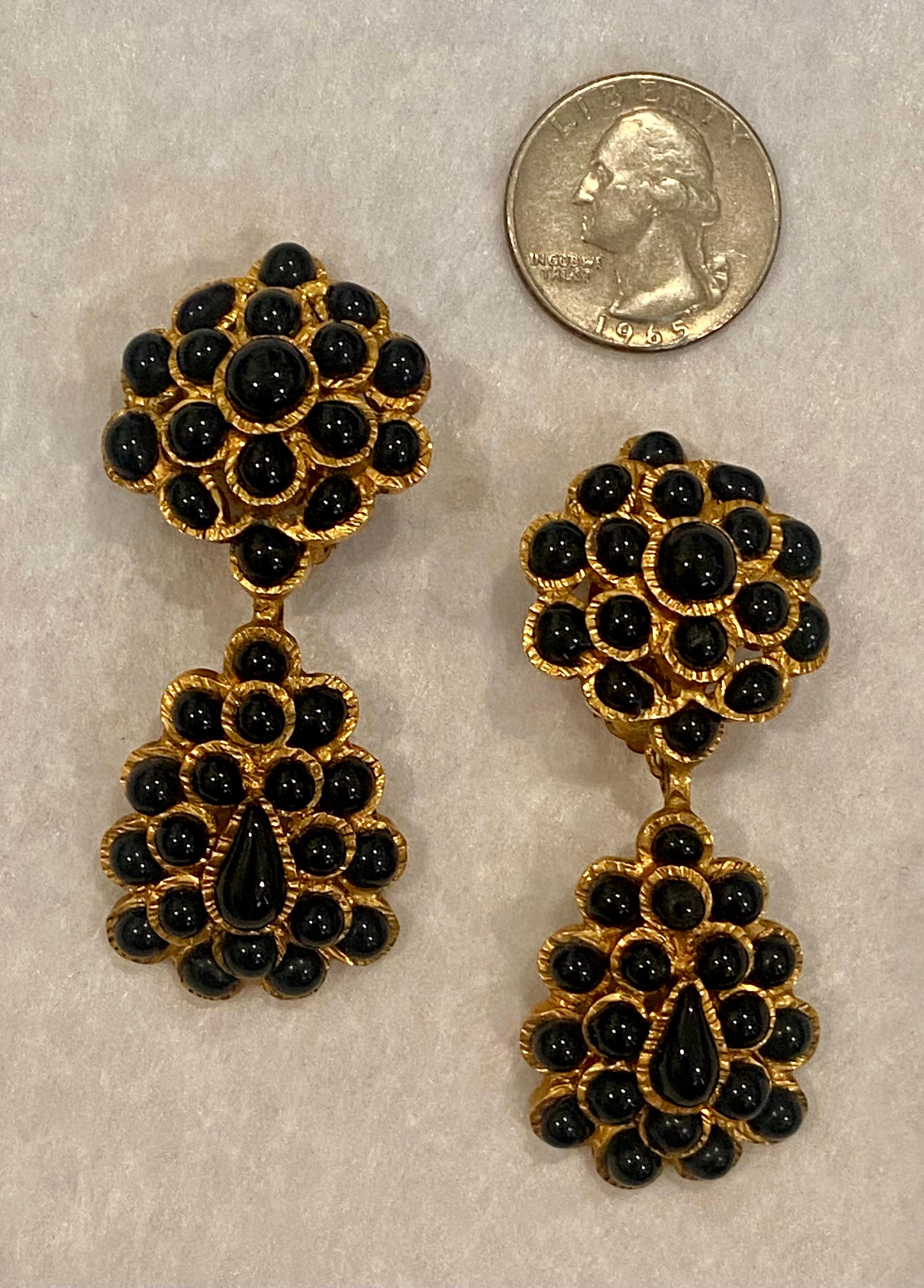 Nous vous présentons une superbe paire de boucles d'oreilles pendantes en verre noir Gripoix de Chanel, de la collection d'automne 1995. Chaque boucle d'oreille à clip mesure 1 pouce de large et 2,5 pouces de long. La technique Gripoix est un