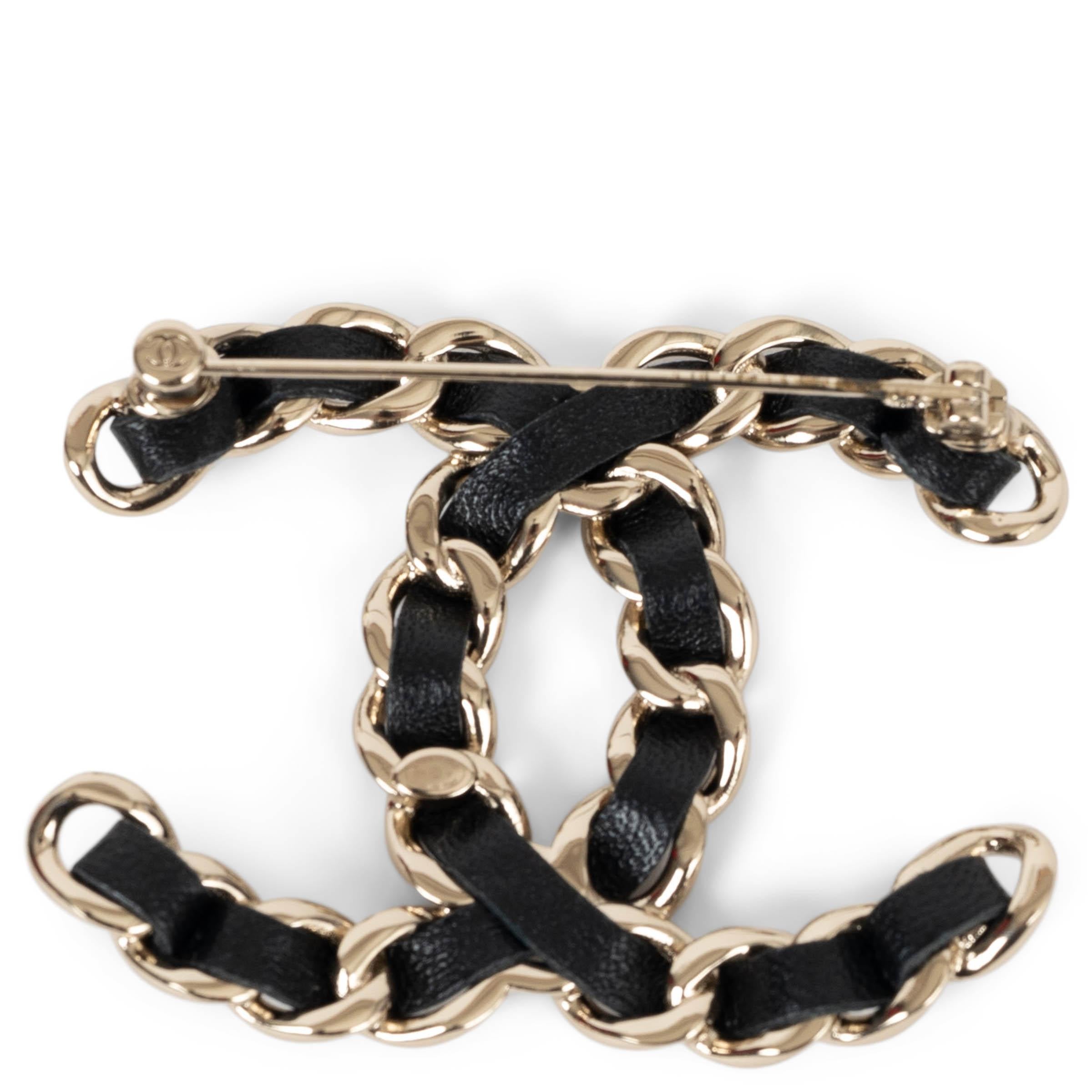 This 100% authentic Chanel CC brooch in gold-tone metal is a timeless expression of the house’s iconic style. Designed with a chain interwoven with black lambskin leather, it pays homage to the brand’s signature handbag detailing. A sophisticated