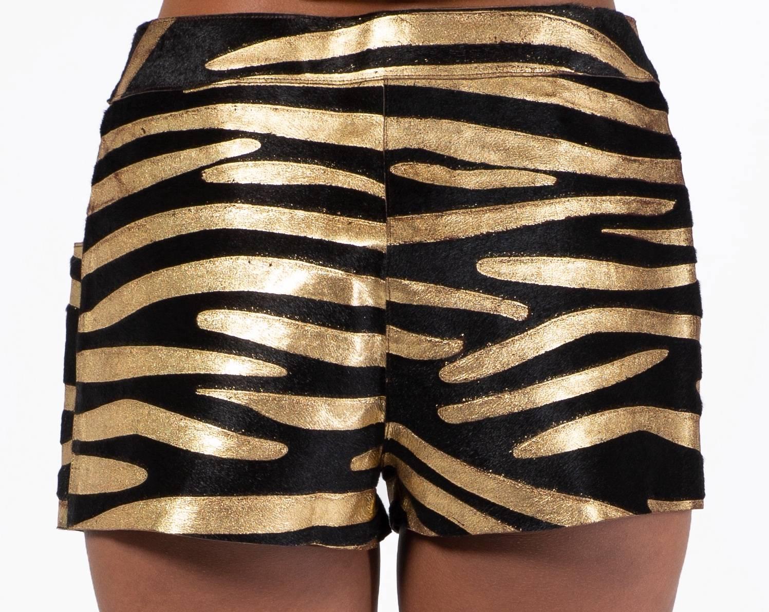Chanel Zebra shorts from the Cruise 2001 collection. Done  in calfskin of metallic  gold and black zebra stripe. Closes in the front with a concealed zipper and gold button. Fully lined in silk printed with the interlocking CC logo. 