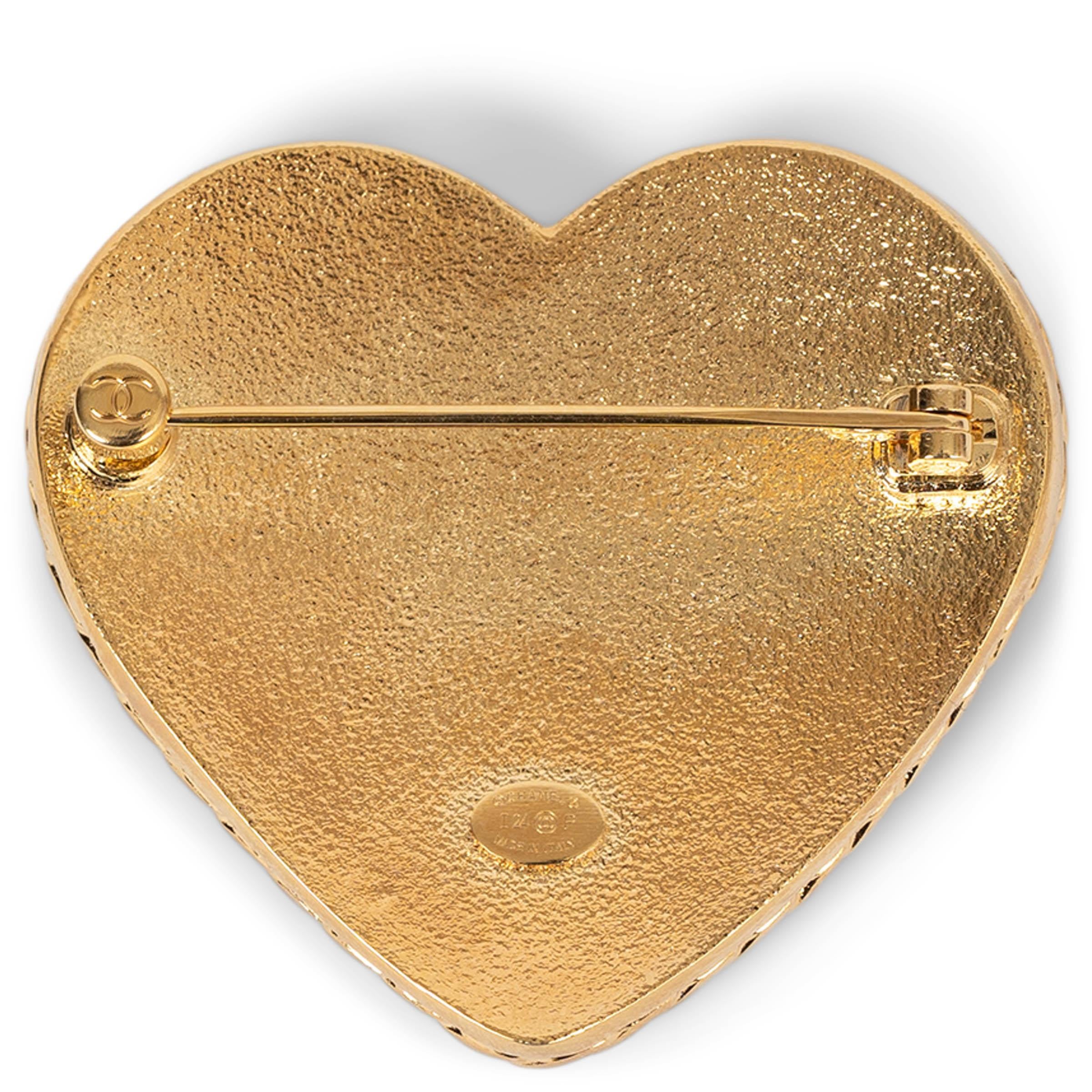 This 100% authentic Chanel heart brooch in gold-tone metal is a unique blend of texture and elegance. Featuring a twisted-edge frame, it is filled with blue denim-like enamel for a modern, casual-chic touch. A hammered CC sits at the center, adding