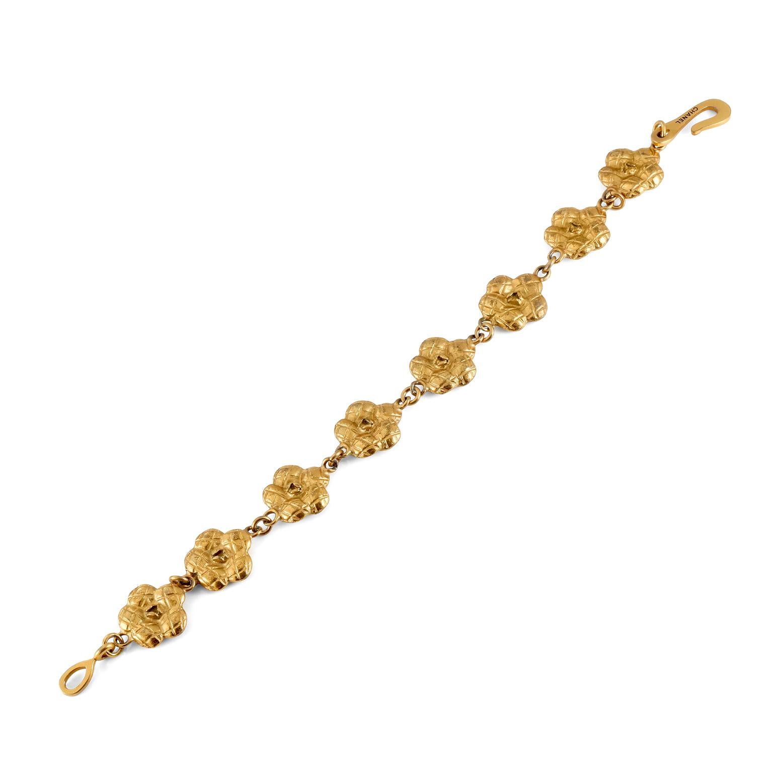 This authentic Chanel Gold Camellia Flower Bracelet is in excellent condition from the late 1990’s.  Eight quilted camellia flowers are linked together in this classic bracelet.  Approximately 8 inches.  Made in France.  1998 production. Pouch or