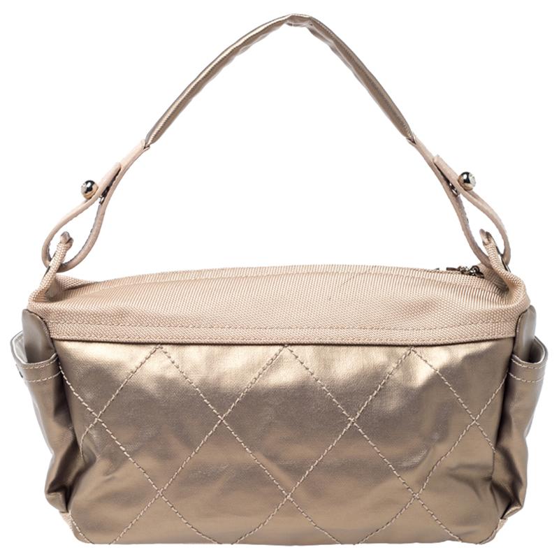 Chanel's Paris Biarritz Hobo is designed in a gold-coated canvas body detailed with quilting. It comes with a top zipper, side pockets for easy access and a top shoulder strap. The spacious interior can hold all your essentials with great ease. It