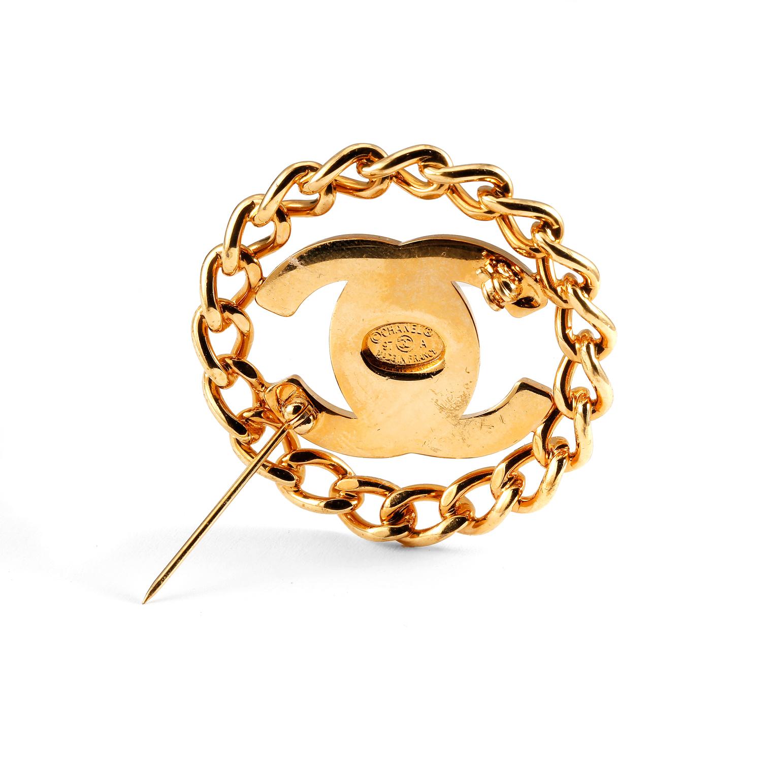 These authentic Chanel Gold CC Clasp with Chain Surround Pin is in very good condition from the Fall 1997 collection.  Gold tone interlocking CC “twist lock” clasp is centered within a circular linked chain.  Made in France.

Approximately 3.5 cm