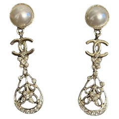 CHANEL - Boucles d'oreilles pendantes en cristal CC et perles florales en or