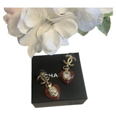 Boucles d'oreilles pendantes CHANEL en forme de cœur, en or CC, avec cristaux et émail rouge