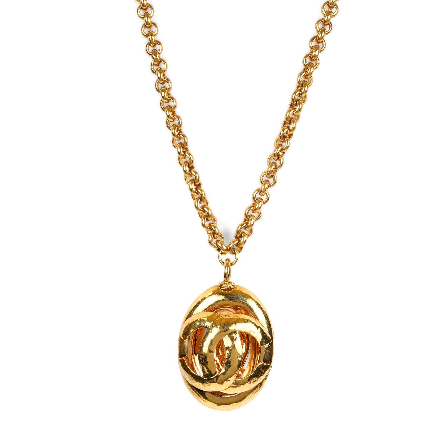 This authentic Chanel Gold CC Oval Pendant Necklace is in excellent condition from the early 1990’s.   A large gold tone oval CC medallion dangles from a rolo style chain. Intentionally hammered finish.  Chain approximately 30 inches/ pendant 2.5