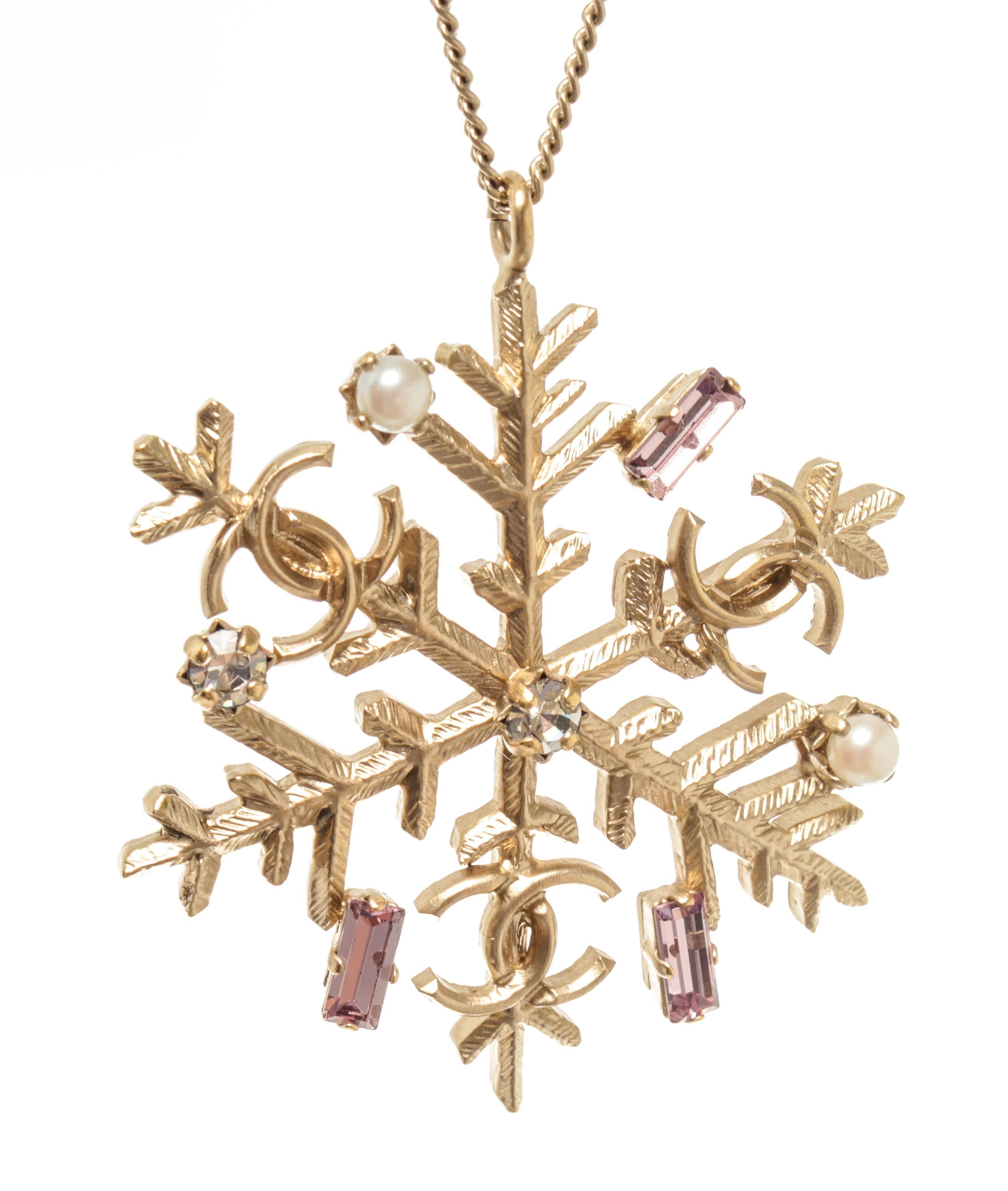 Chanel gold CC snowflake necklace with gold-tone hardware, spring ring closure with two-length options, snowflake pendant with faux pearls, rhinestones, stones, and the CC logos.


770081MSC