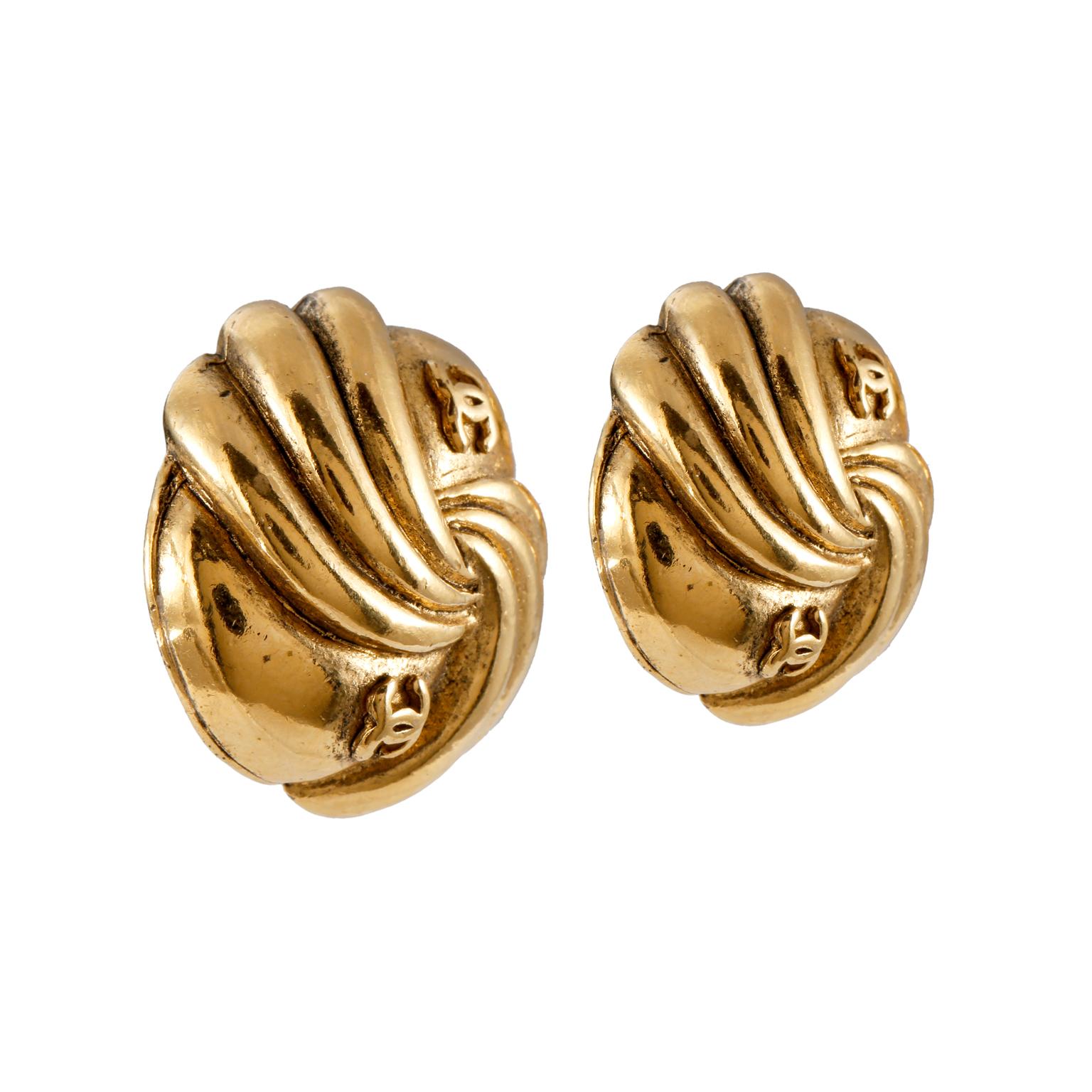 These authentic Chanel Gold CC Swirled Button Earrings are in very good condition from the mid to late 1980’s.  Gold tone swirling pattern with interlocking cc’s. Clip on closure.  Made in France.  

