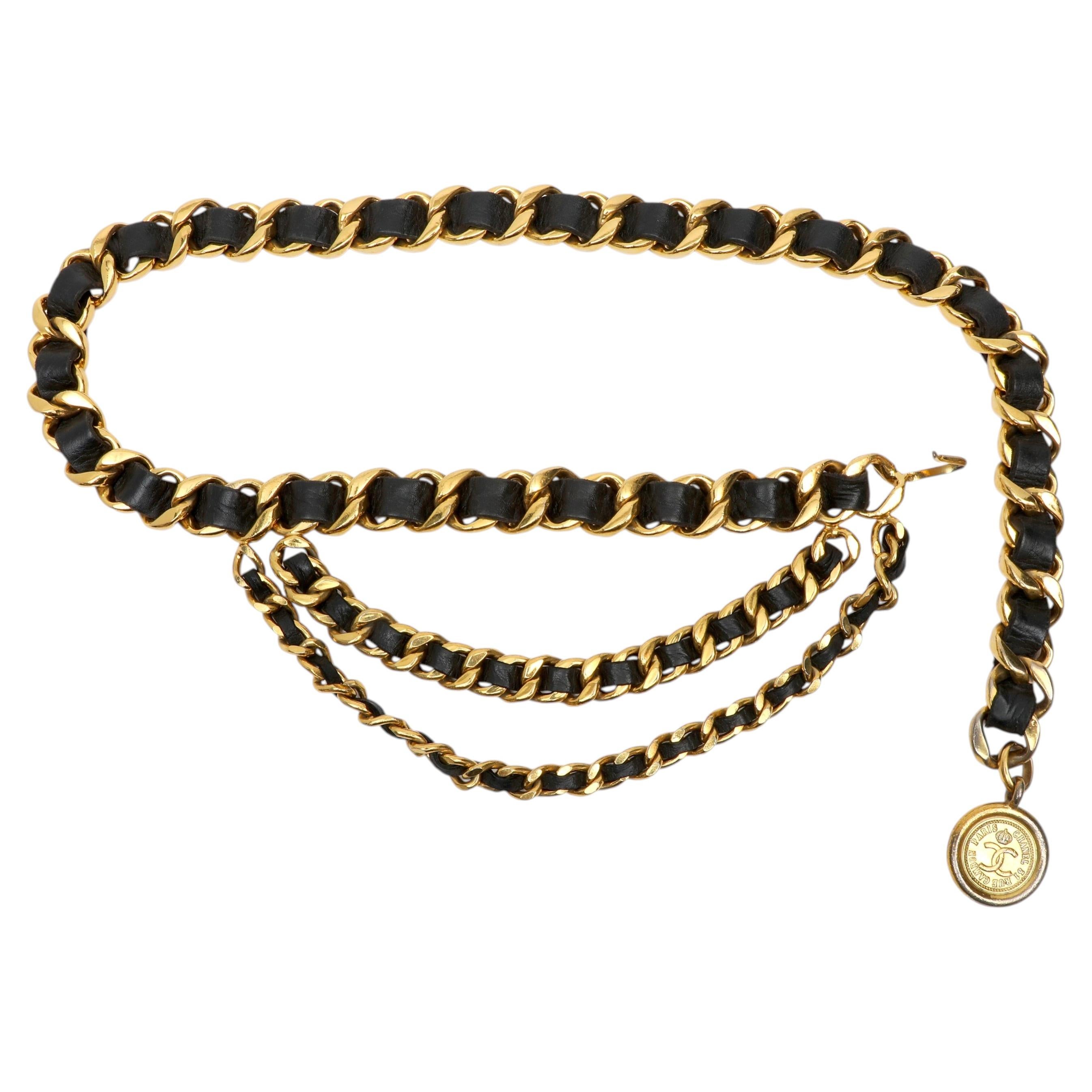 Cinturón Chanel de cadena dorada y piel negra con medalla CC