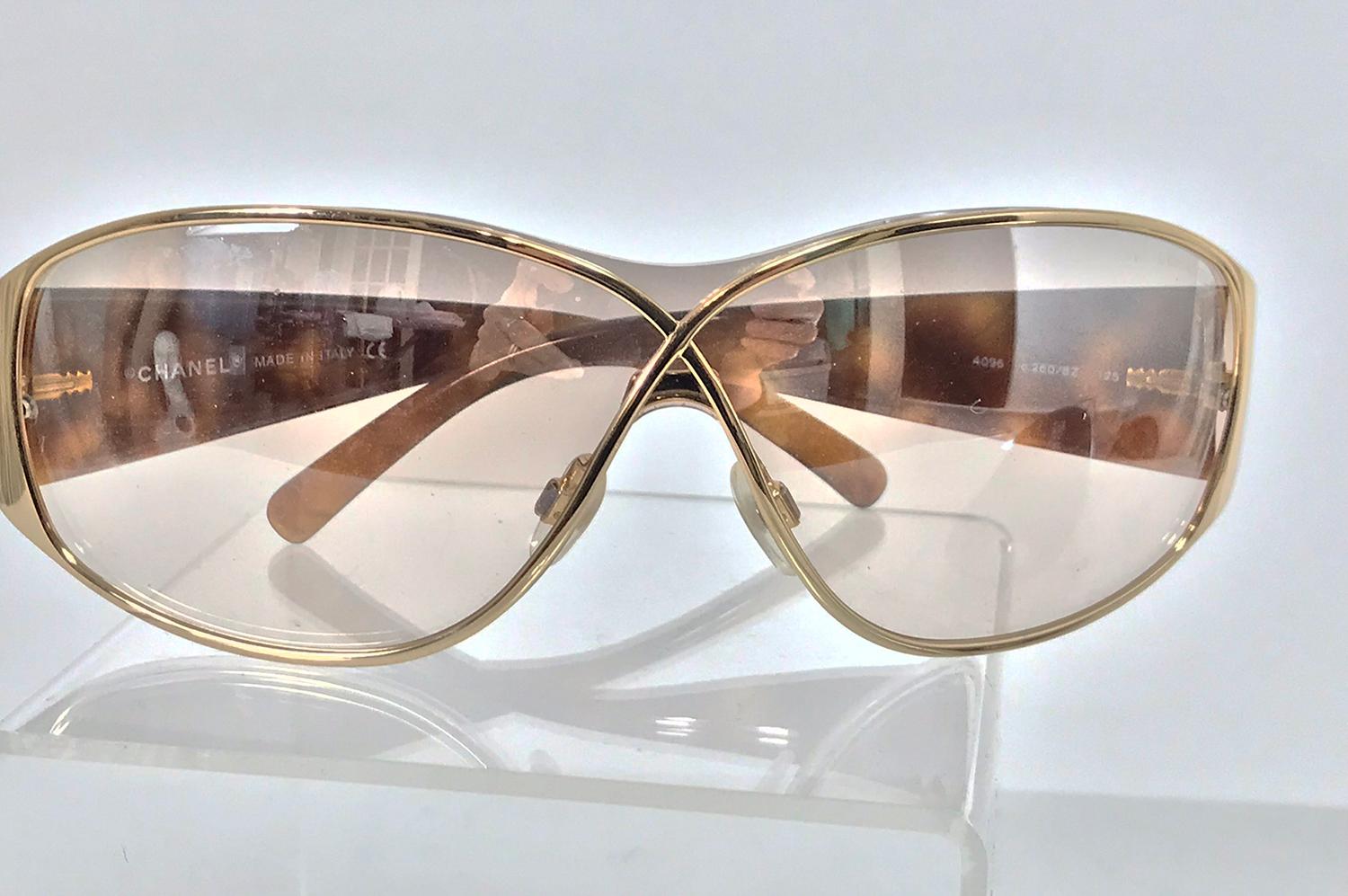 Chanel gold crossover frames with faux tortoise shell side ear pieces together with the rhinestone case. These chic sunglasses have a sleek look curving at the front to the sides, they have quilted light tortoise shell sides, the fronts are thin