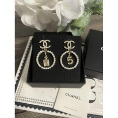 CHANEL - Boucles d'oreilles pendantes en cristal doré et perles CC