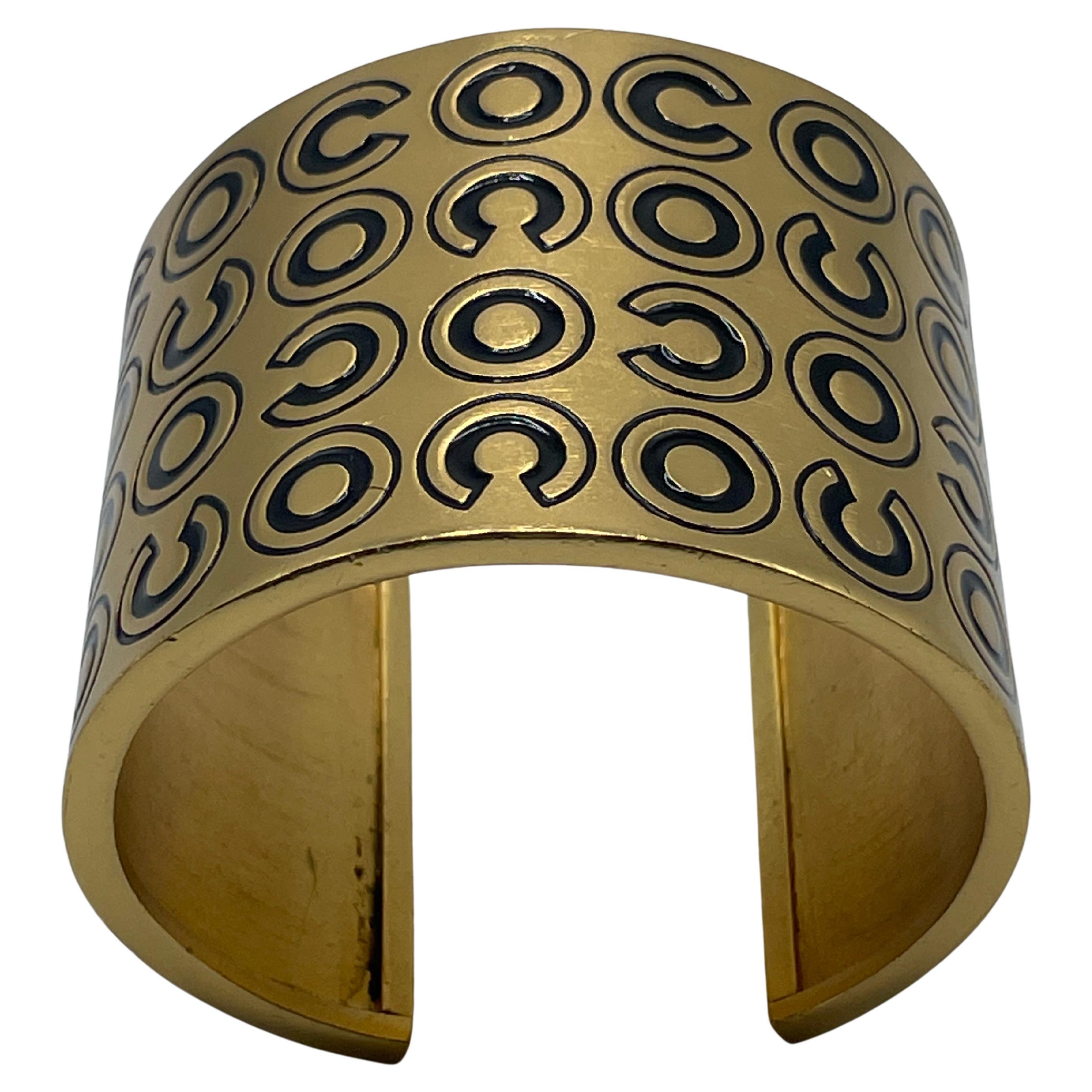Gold-plated COCO bracelet cuff. This cuff is adorned with gold-tone metal and black enamelled lettering reading 