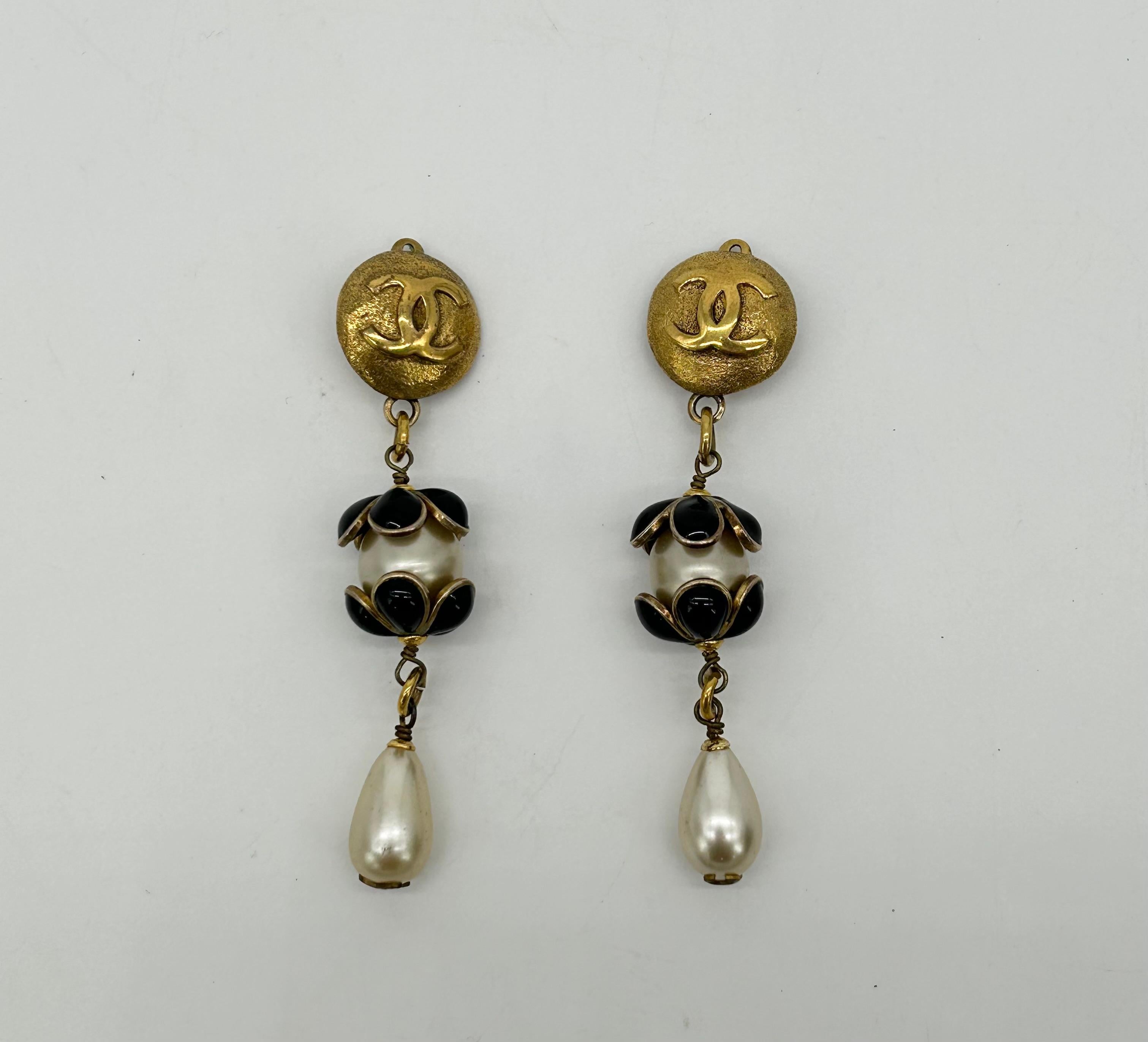 Chanel Gold Enamel Pearl Teardrop Earrings In excellent condition. Three separate parts make up these gorgeous dangling design. Top part features gold round with CC Chanel logo embossed on front and clip on back. This is linked to the center portion