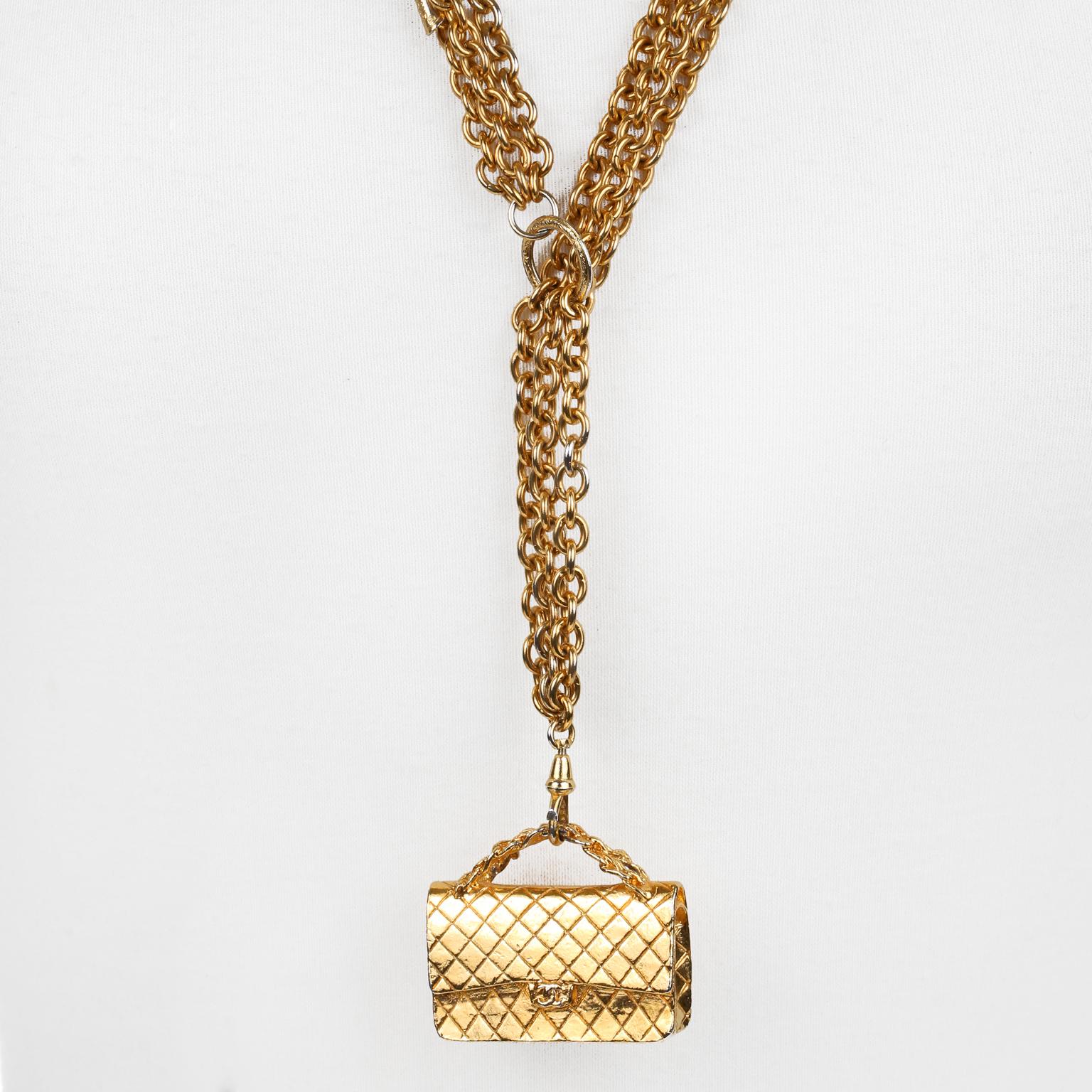 This authentic Chanel Gold Flap Bag Pendant Necklace is in excellent vintage condition from the 1970’s.  Lariat style gold tone triple chain.  Gold quilted flap bag charm dangles daintily from the end.  Chain is approximately 32 inches. Bag pendant