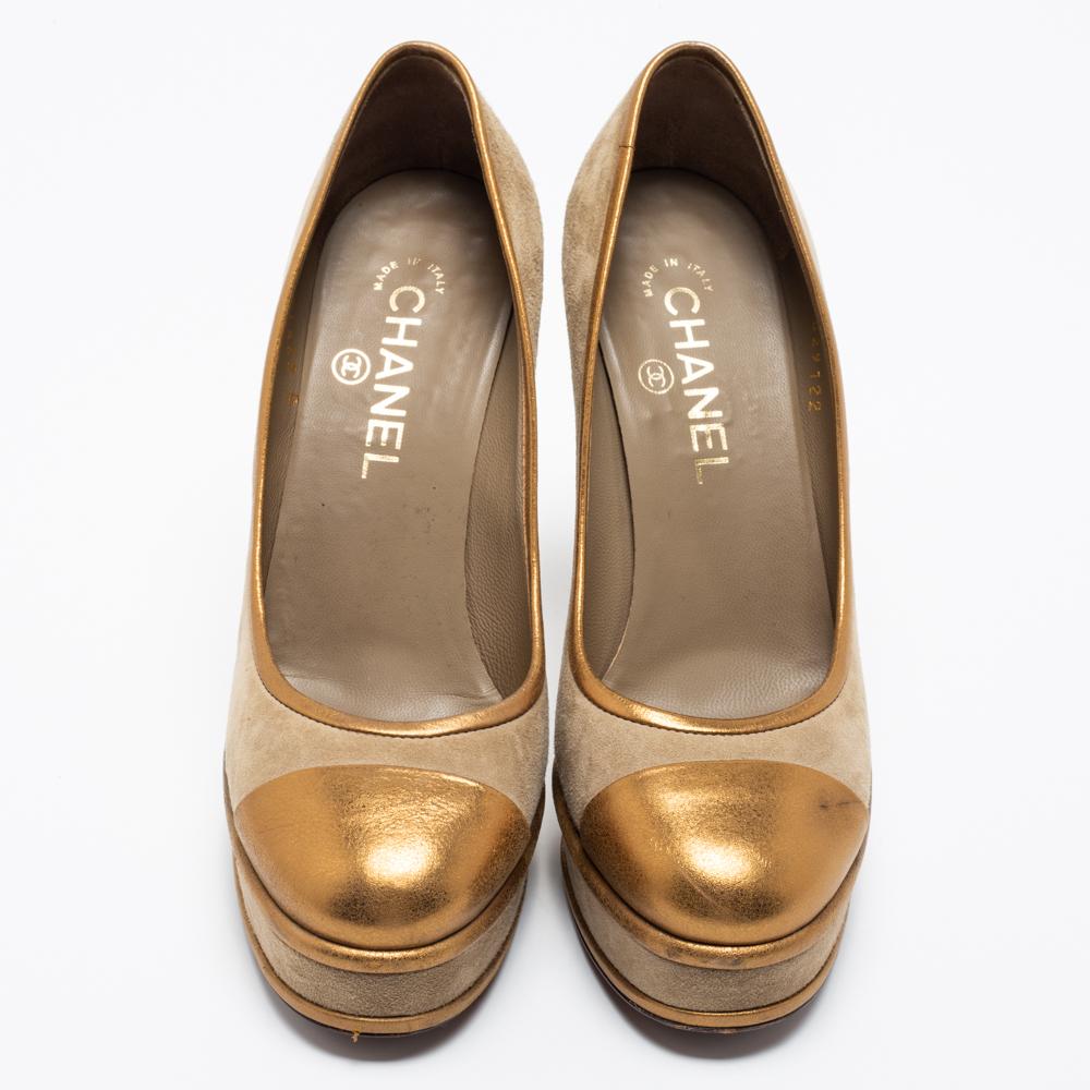 The gold trims against the grey exterior offer this pair of Chanel pumps a luxe contrast. Created from suede and leather, it is easily recognizable with a 'CC' motif at the back, and its 12cm heels is balanced on platforms for a smooth
