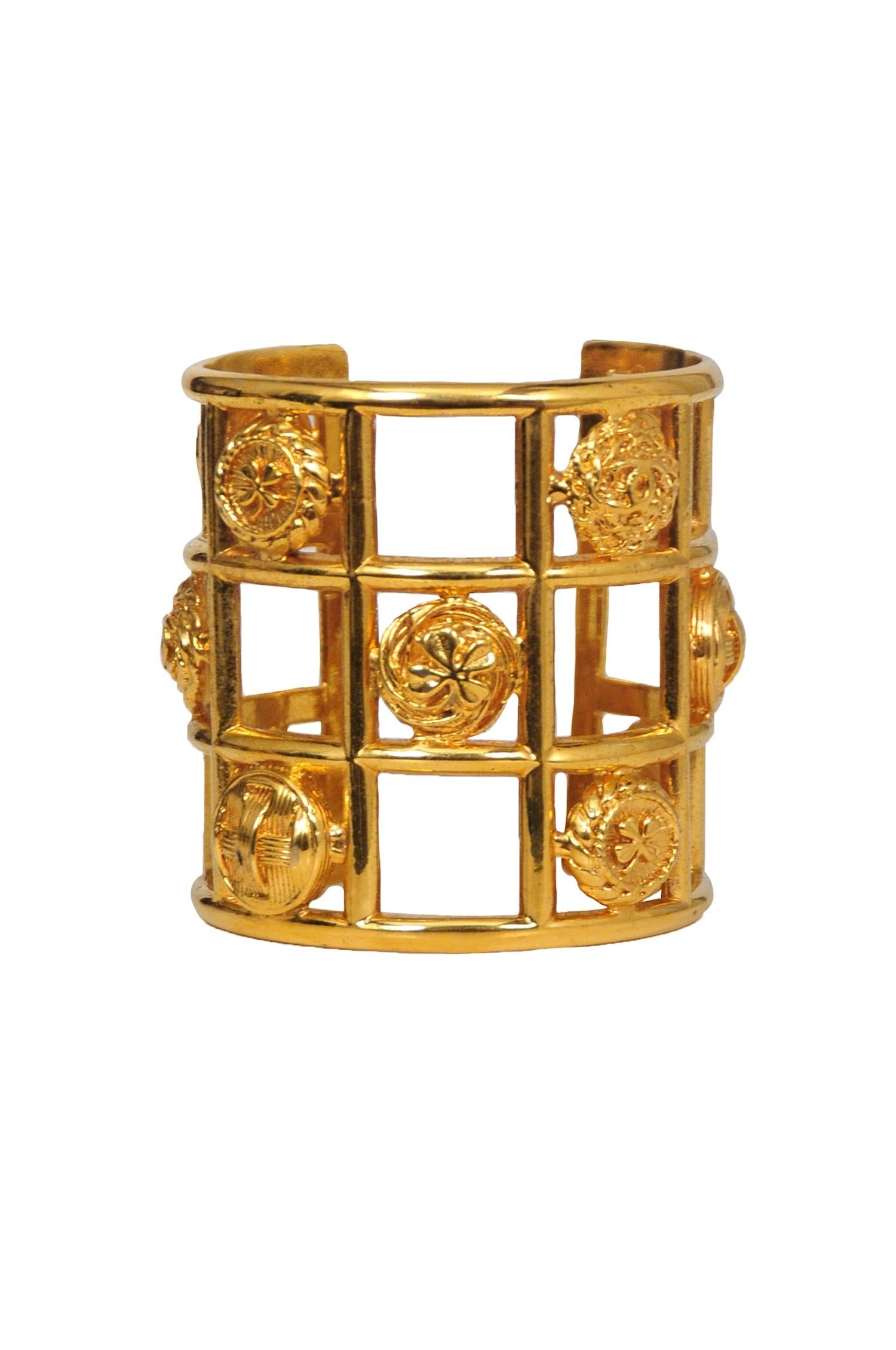 Vintage Chanel gold tone cuff featuring a grid design with four-leaf clover and CC logo charm details.

Excellent Vintage Condition.

Measurements: 
Height 3