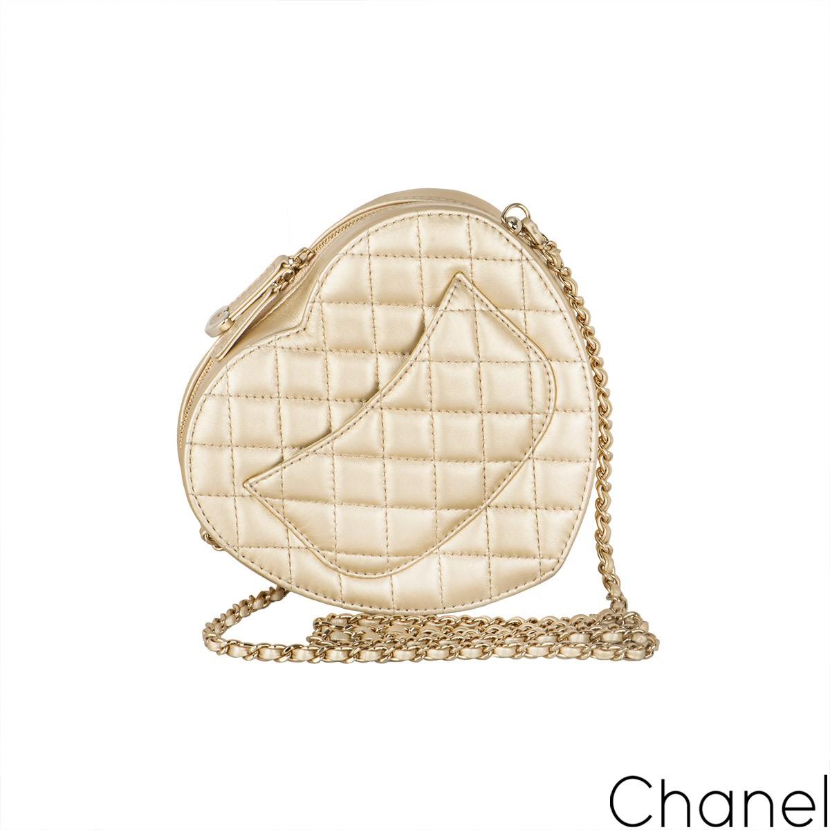 A coveted gold Chanel Heart Bag. The exterior of this Heart Bag is crafted with gold lambskin leather in the signature diamond style stitching with light gold-tone hardware and has a signature logo zipper pull. It features a front flap with