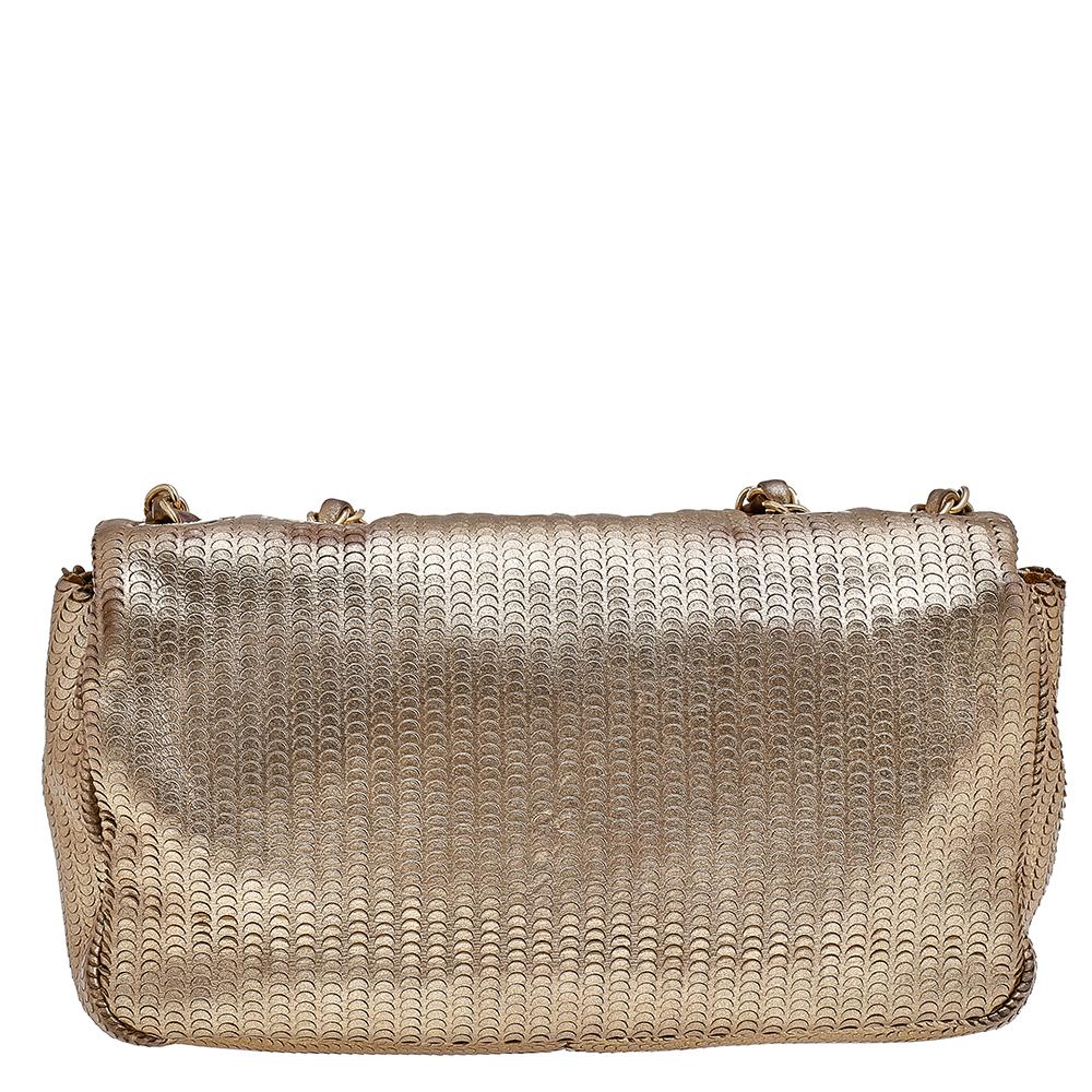 We are in utter awe of this flap bag from Chanel as it is appealing in a surreal way. Exquisitely crafted from gold leather, it bears the signature label on the fabric interior and the iconic CC turn-lock on the flap. The piece has gold-tone