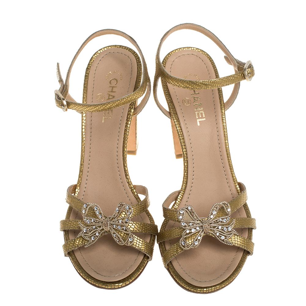 Dazzle onlookers when you walk around in these open-toe sandals from Chanel. Crafted from gold leather, these elegant sandals are embellished with butterfly motifs on the vamp straps and equipped with buckle ankle fastenings. They have leather