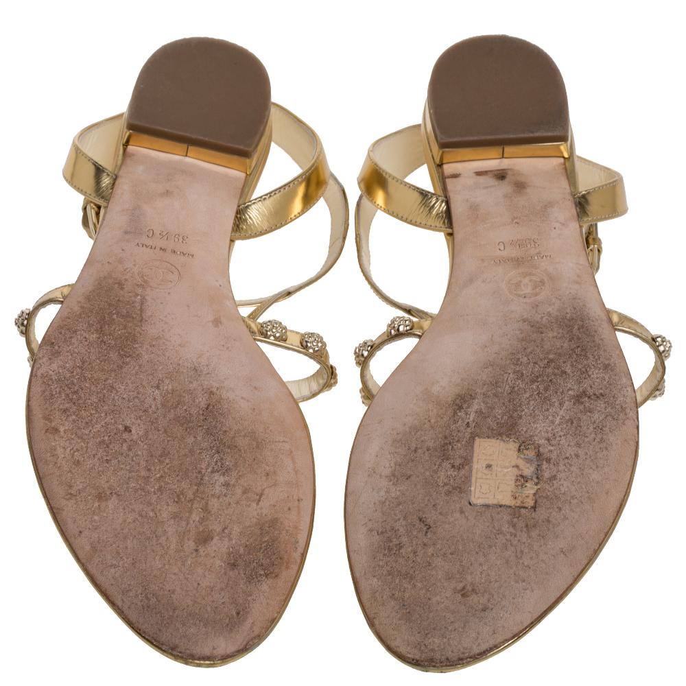Brighten up a casual look with these stunning sandals from Chanel. Crafted from gold leather, these thong sandals are accented with signature Camellia motifs on the vamps and feature labeled insoles.

