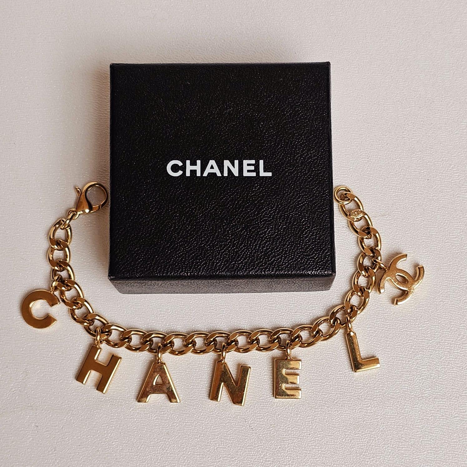 Chanel Bracelet à breloques logo en or en vente 6